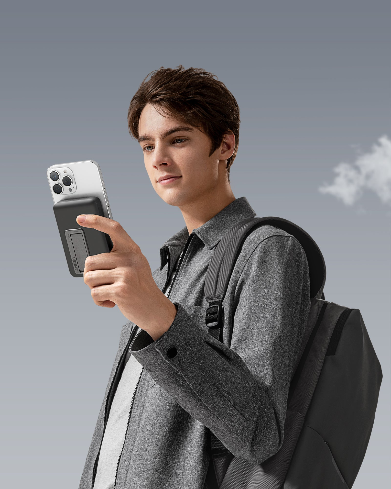 Mann hält Telefon mit schwarzer Powerbank, Himmel Hintergrund.
