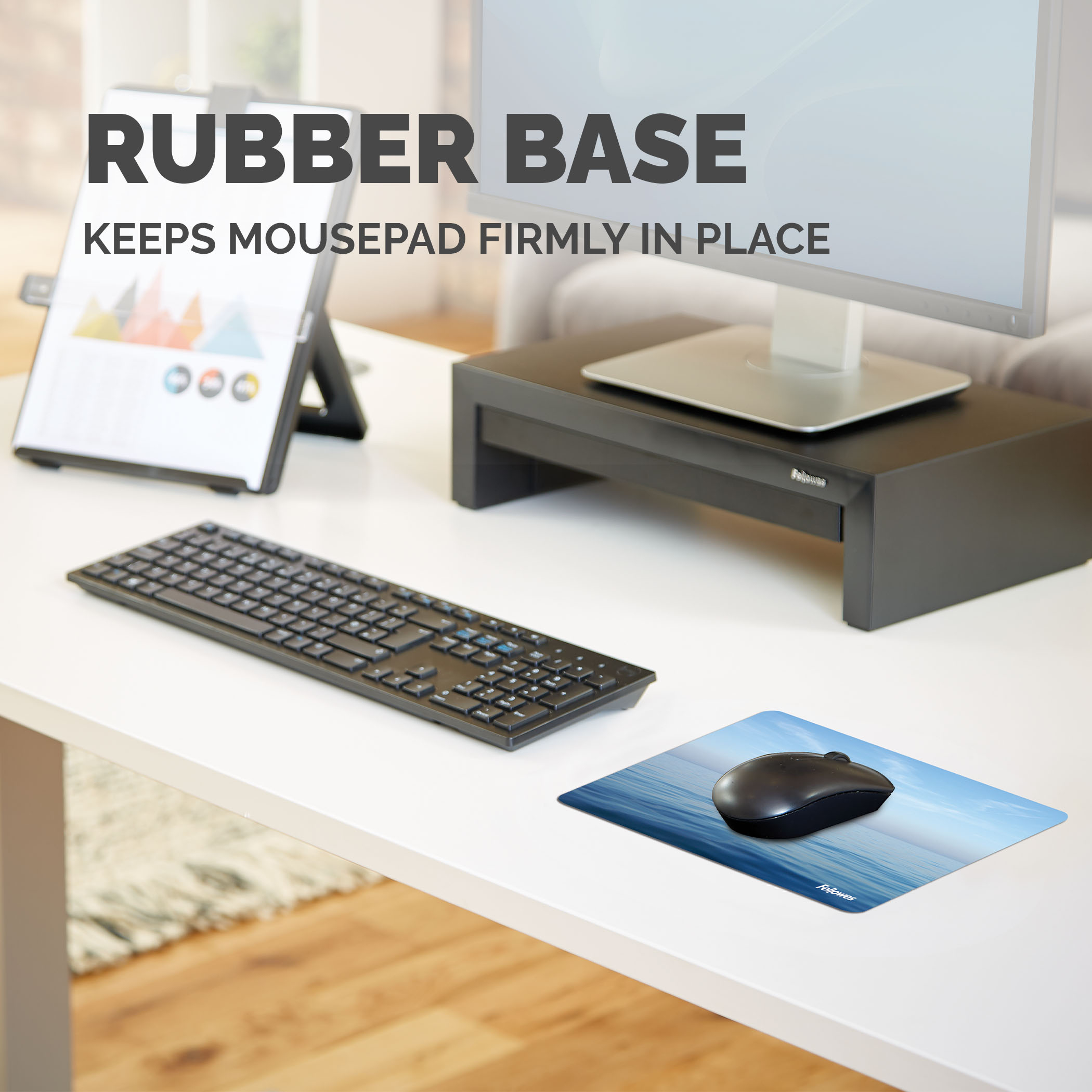 Een bureau-opstelling met muis, muismat, toetsenbord en monitor. De muismat heeft een water- en luchtafbeelding.
