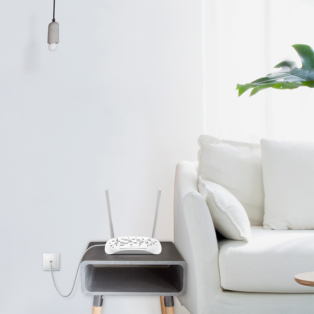 İki antenli beyaz bir yönlendirici. Beyaz bir kanepe ve bir duvar prizi görülebilir.