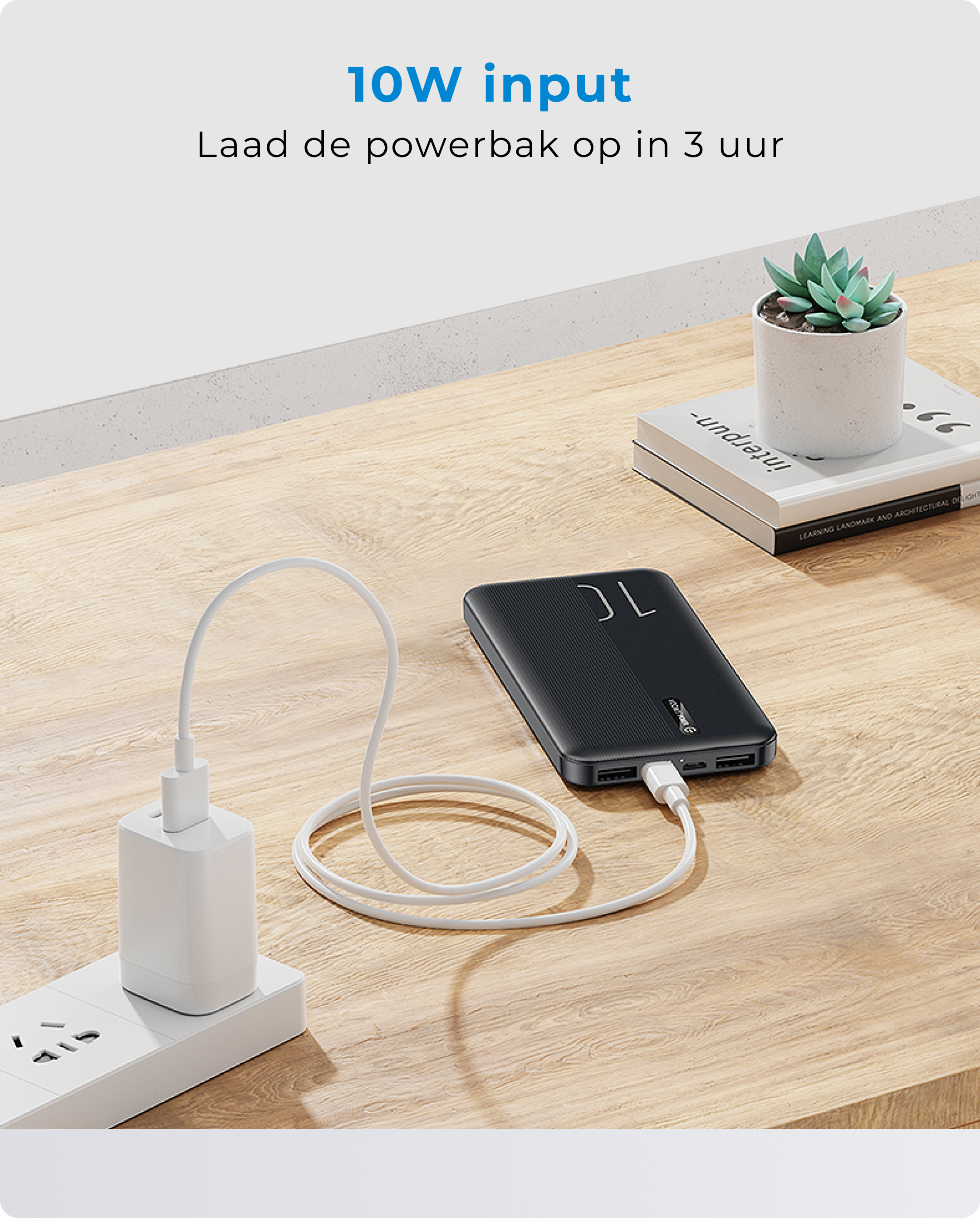 Un power bank nero che carica un telefono tramite un cavo bianco.