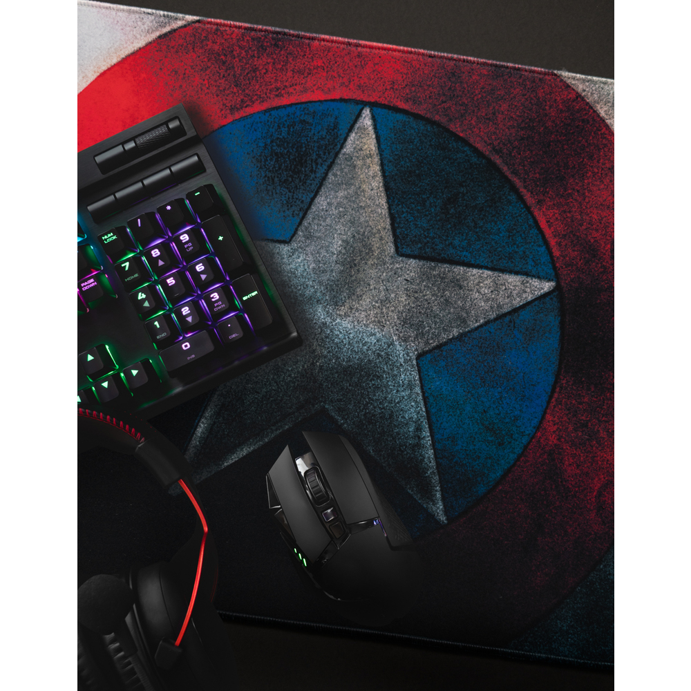 Gaming-Setup: Tastatur, Maus, Kopfhörer und Mauspad mit Captain America Schild.
