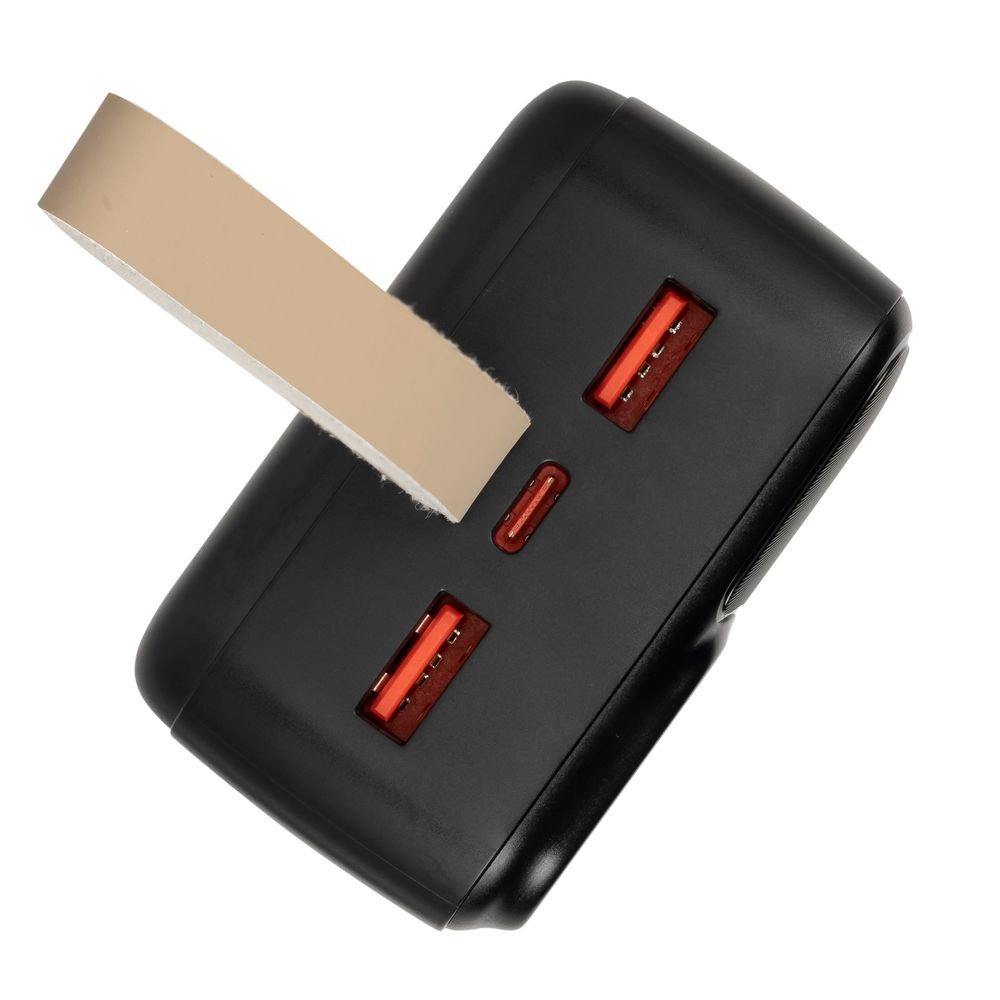 Schwarze Powerbank mit von beigem Klebeband abgedeckten Ladeanschlüssen.