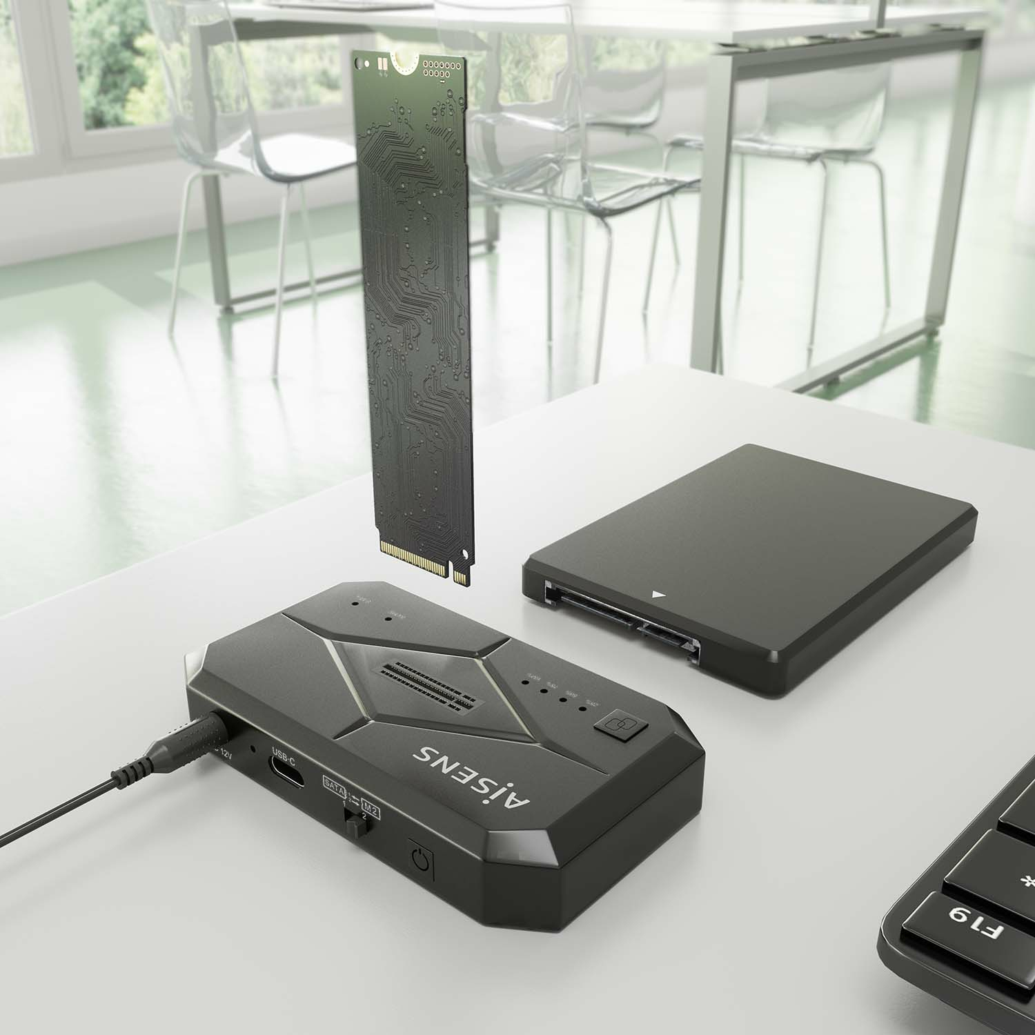 Ein schwarzes Gerät mit einer Leiterplatte, SSD und einer Tastatur auf einem weißen Schreibtisch mit Fenster im Hintergrund.