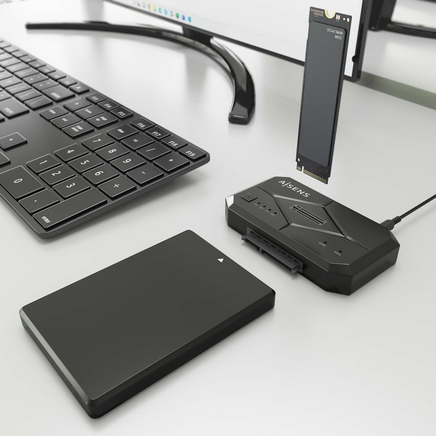Schwarze Tastatur, Computerkomponenten und externe Festplatte auf weißer Oberfläche.
