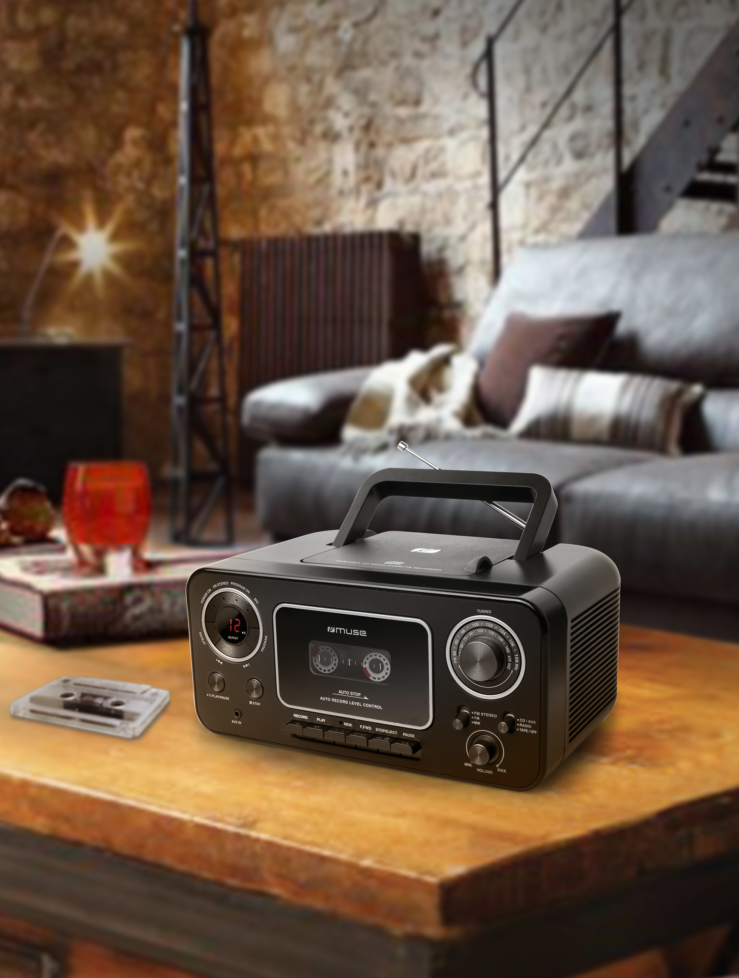 Radio reproductor de casete negro sobre una mesa, con casete y fondo de habitación.