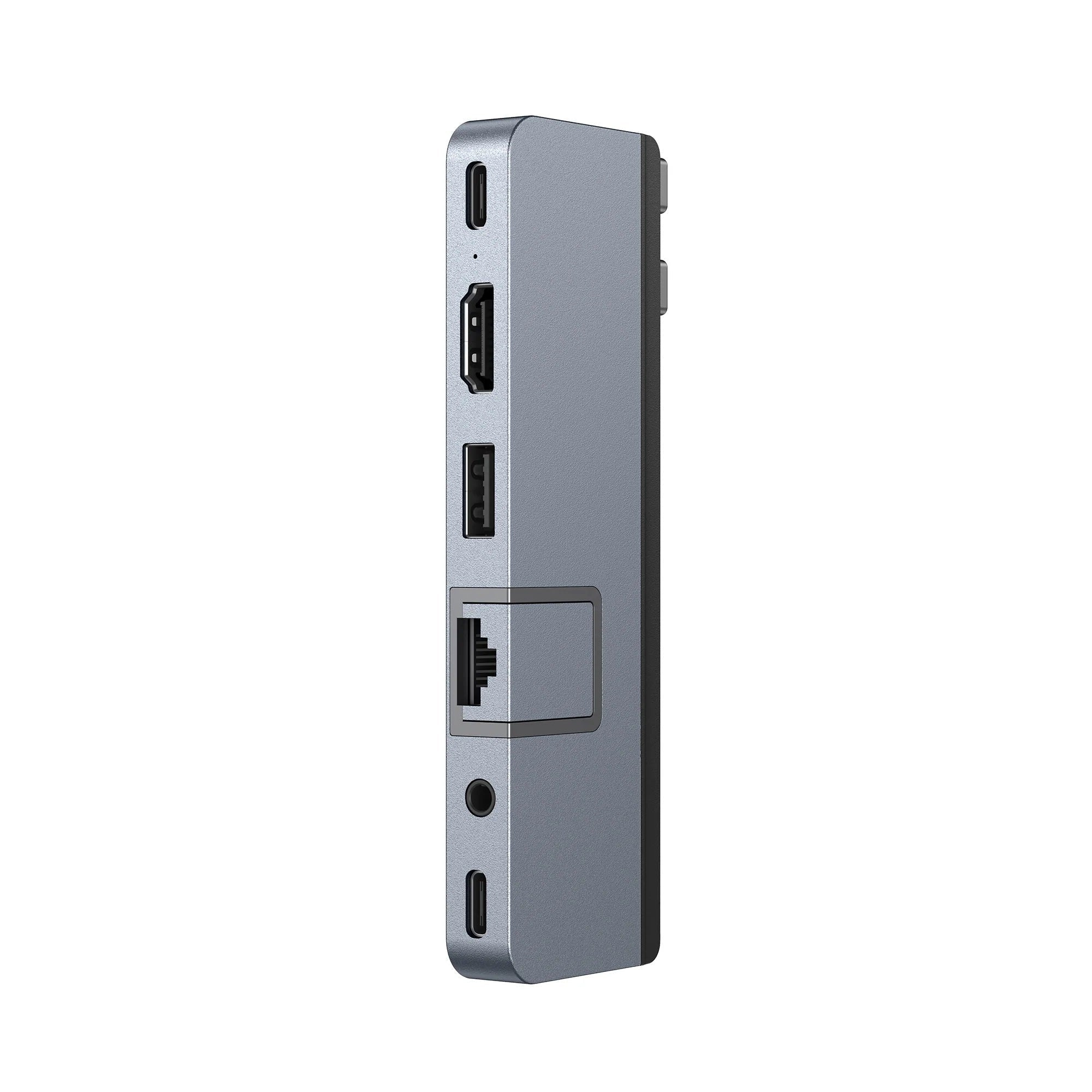 Adaptador multipuerto gris plateado con varios puertos, fondo blanco.