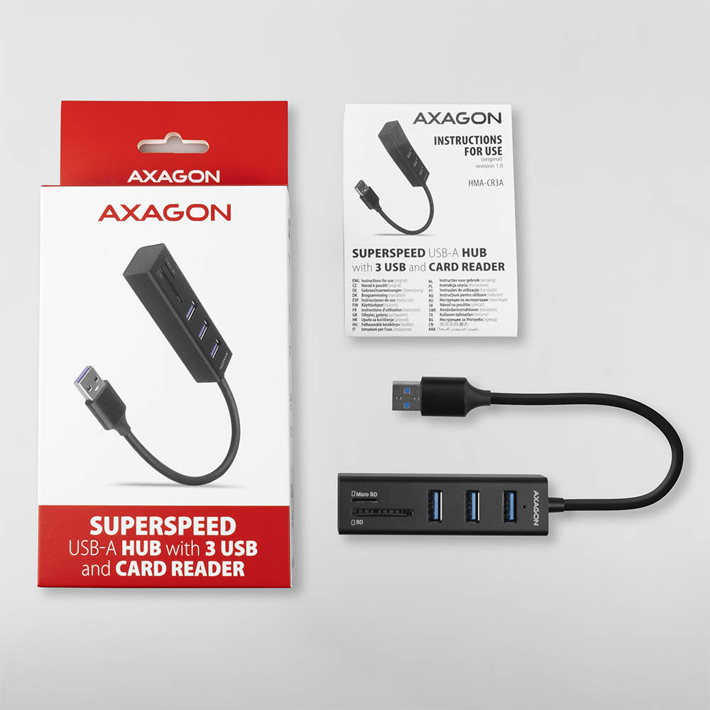 USB-Hub mit Kartenleser in einer Box, mit separatem Hub und Bedienungsanleitung daneben.