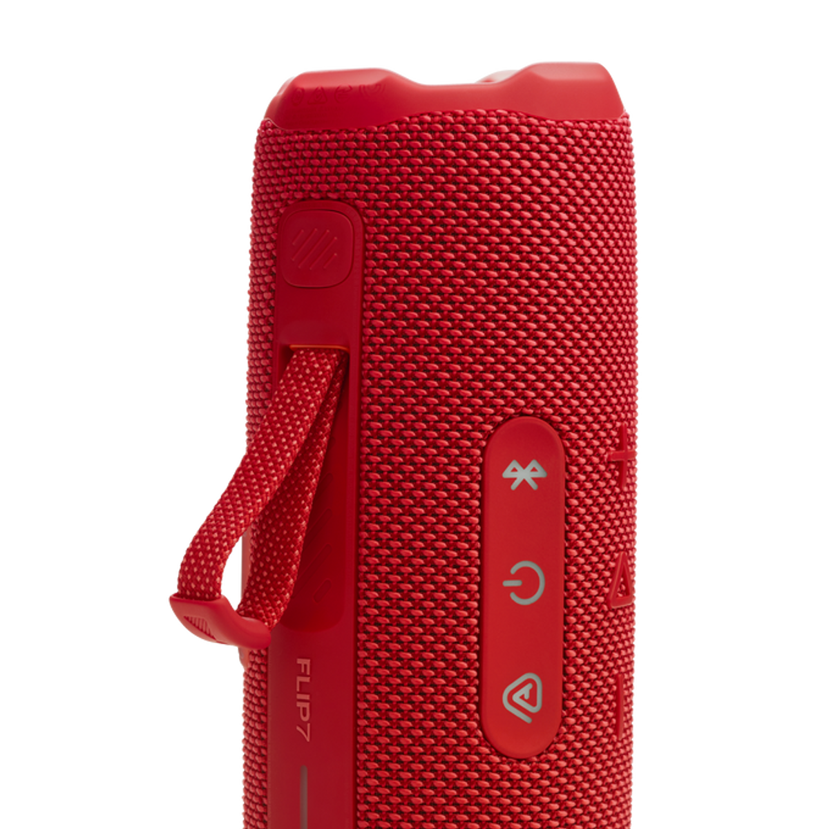 Enceinte JBL Flip 7 rouge avec boutons, une sangle et une surface texturée.