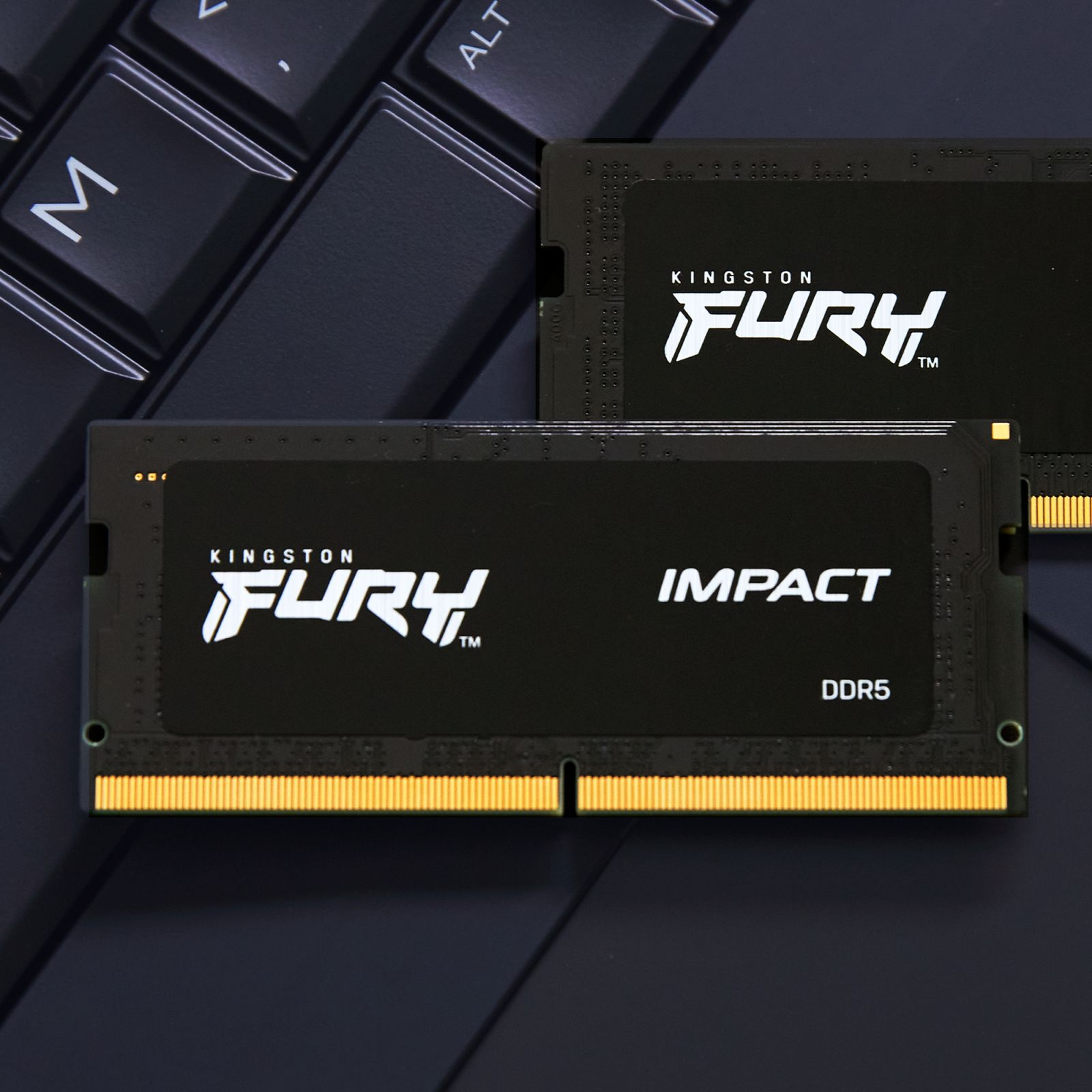 Two black RAM sticks with white text on a black laptop keyboard.
