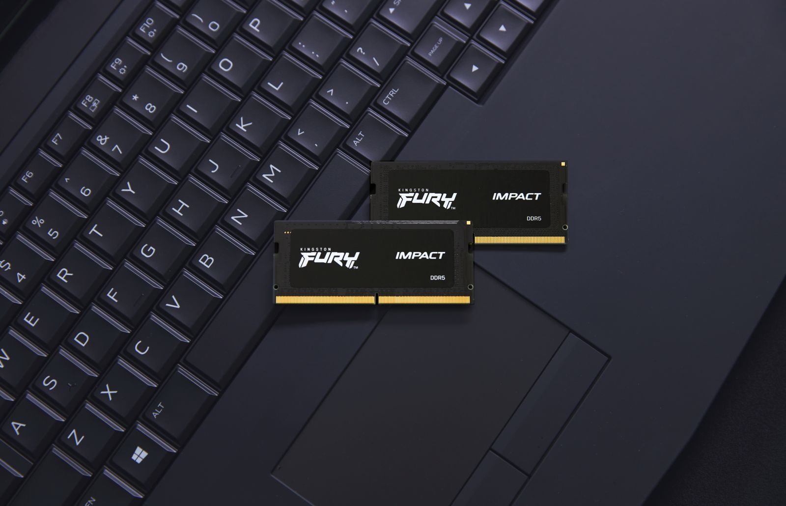 Dwa moduły RAM na klawiaturze laptopa, widoczne logo Kingston Fury.