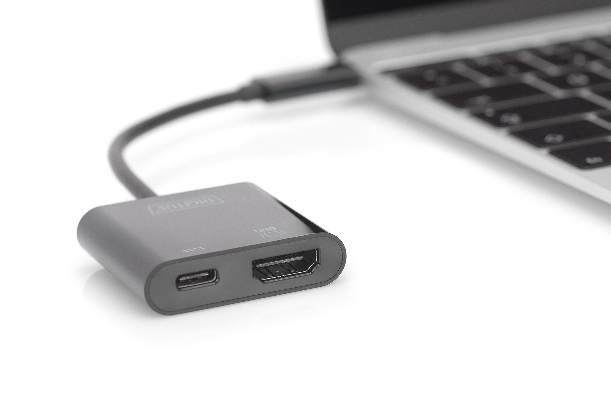Ein grauer Adapter, der mit einem Laptop verbunden ist. Der Adapter hat einen Anschluss und einen HDMI-Anschluss.