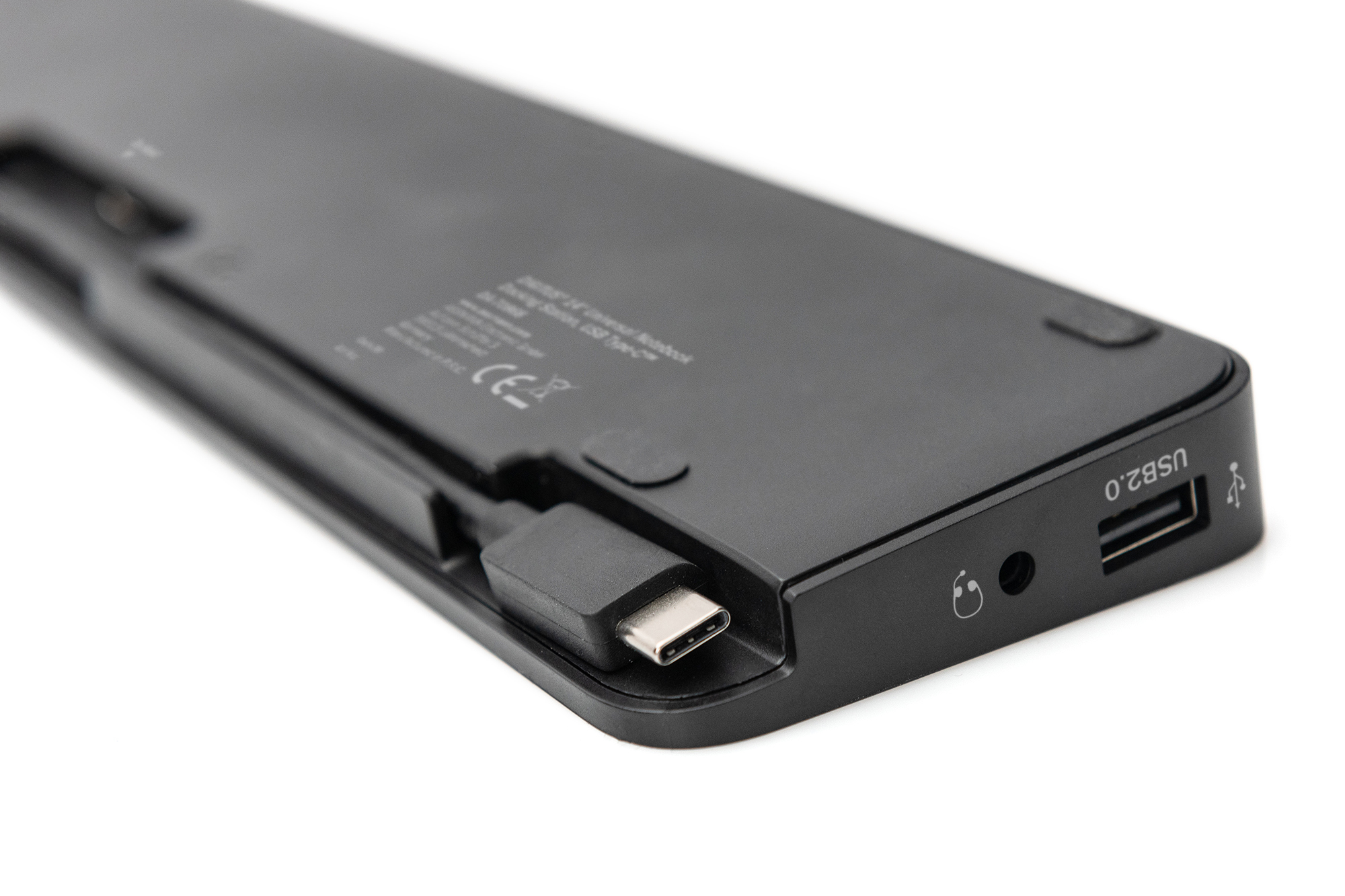 Nahaufnahme der Unterseite eines schwarzen Geräts mit Anschlüssen für USB, Audio und Laden.