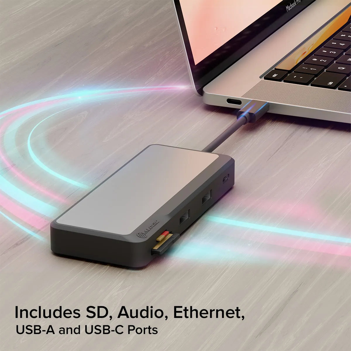 Un hub grigio collegato a un laptop, include porte SD, audio, ethernet, USB-A e USB-C.