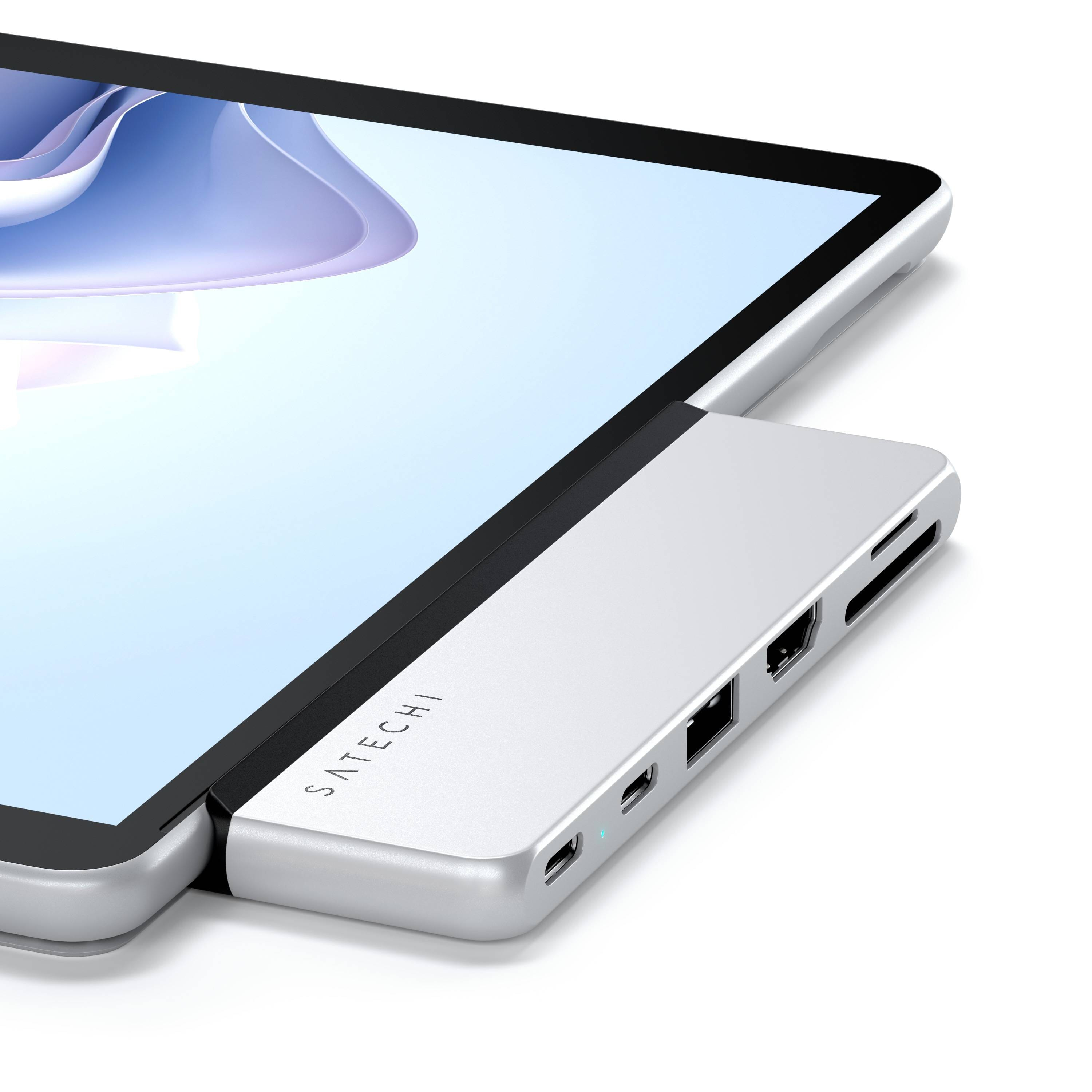 Hub argentato collegato a un tablet. L'hub ha diverse porte e lo schermo del tablet è visibile.