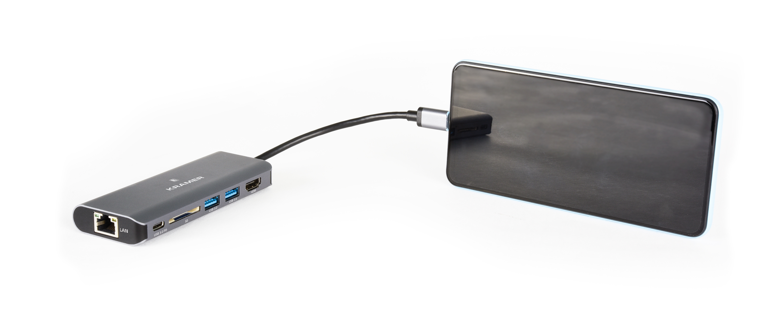 Un hub gris conectado a un teléfono negro con un cable USB-C, sobre un fondo blanco.