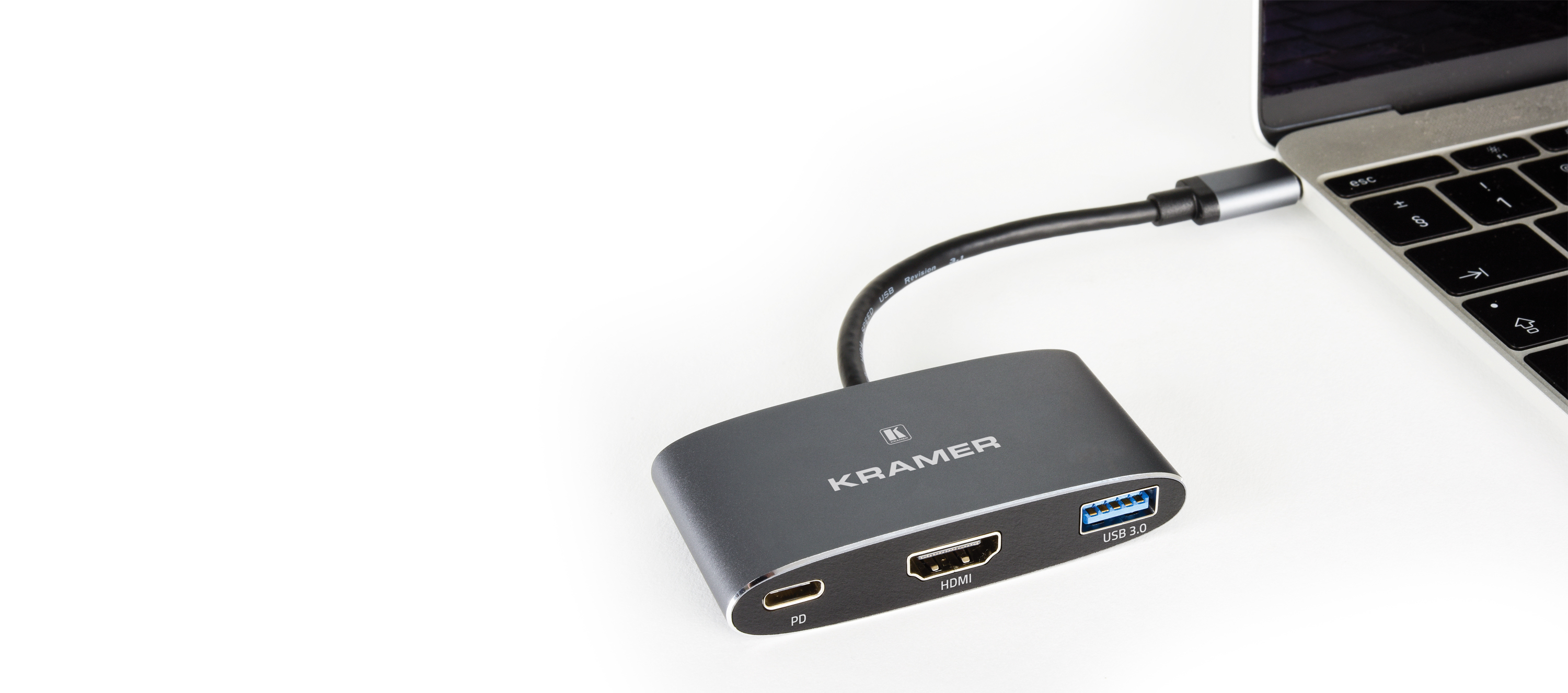 Hub grigio collegato a un laptop con porta USB 3.0 e HDMI.