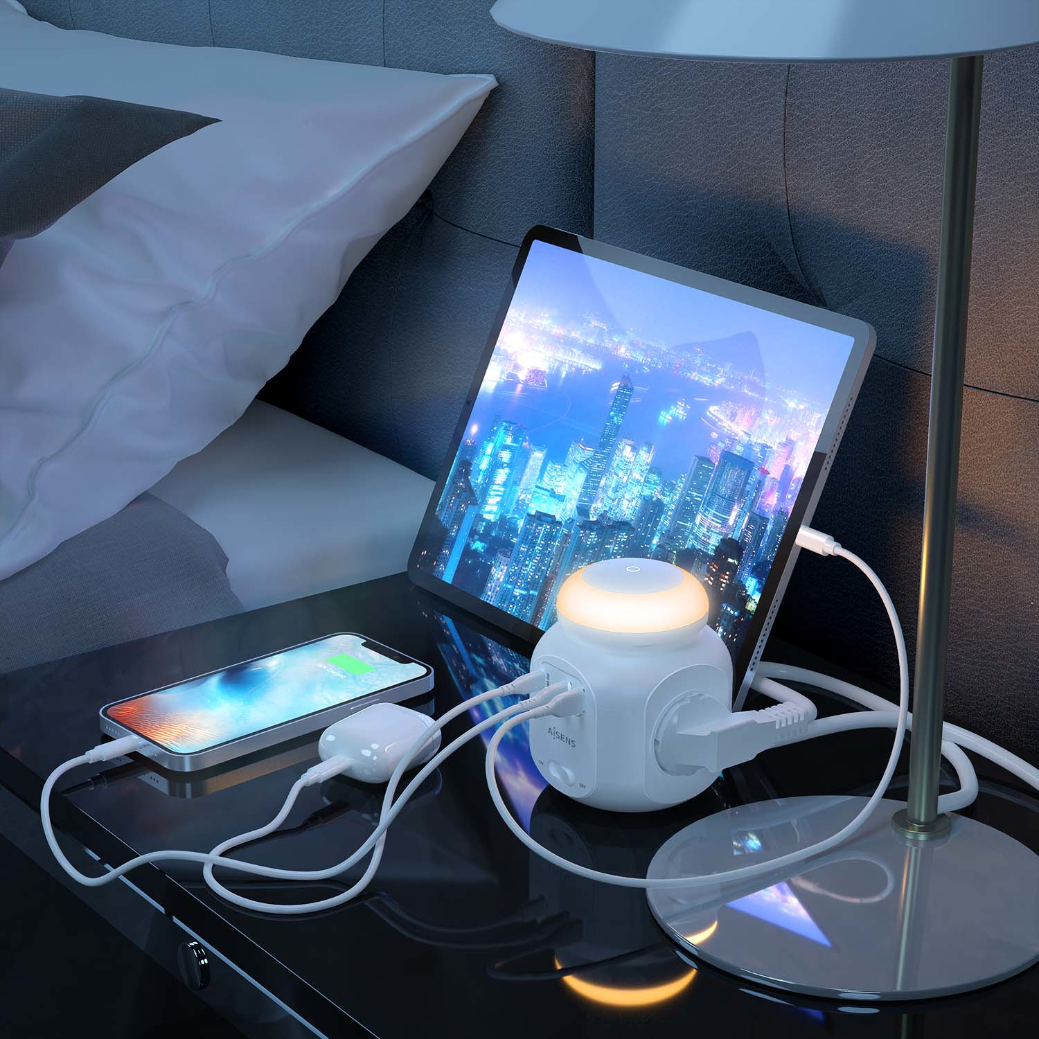 Scena nocna z tabletem, telefonem i stacją ładującą na stoliku nocnym. Po prawej stronie lampa.