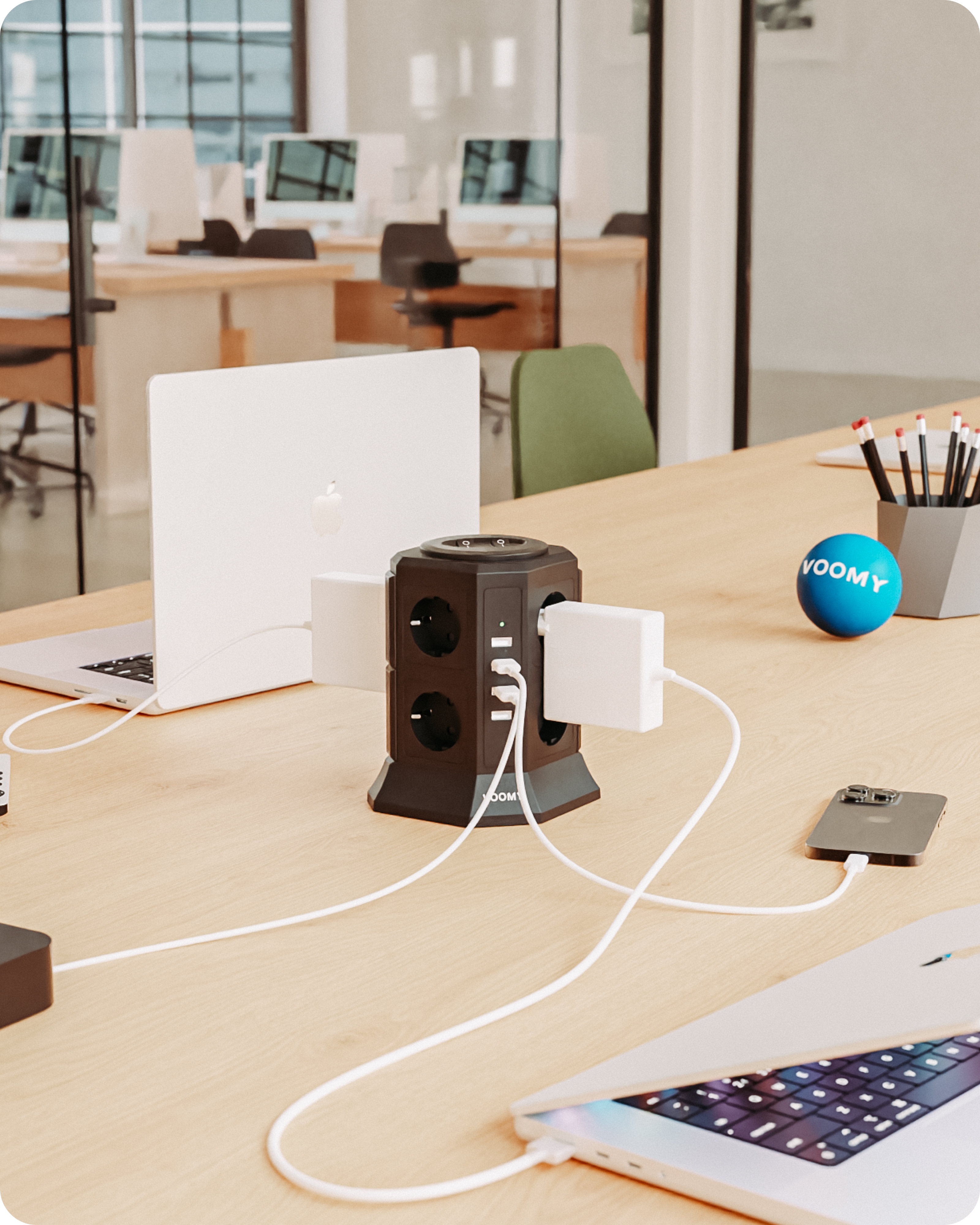 Büro mit Mehrfachsteckdose, die mehrere Geräte auf einem Schreibtisch lädt.
