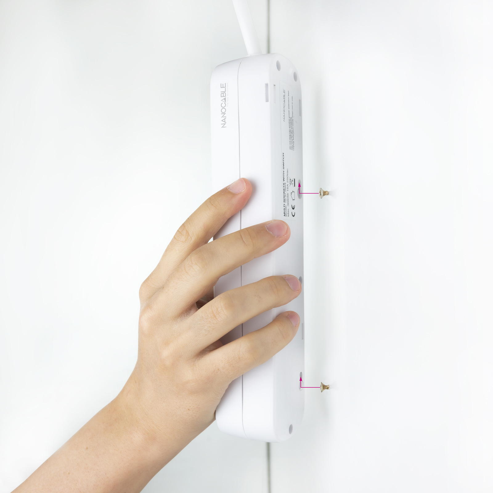 Ręka wkręcająca śrubę w tył białej listwy zasilającej zamontowanej na białej ścianie.