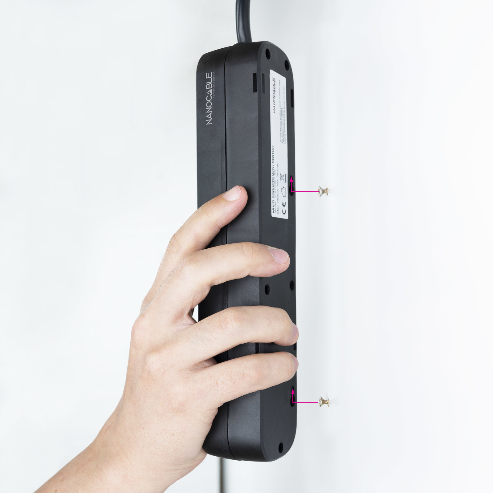 Dłoń trzymająca czarną listwę zasilającą, ze śrubami z tyłu.