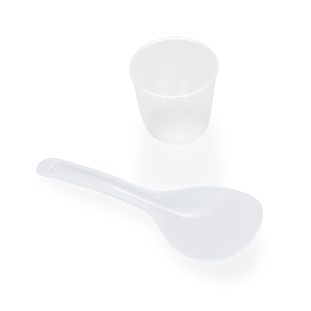 Cuchara de arroz blanca y taza medidora sobre fondo blanco. Vista superior.