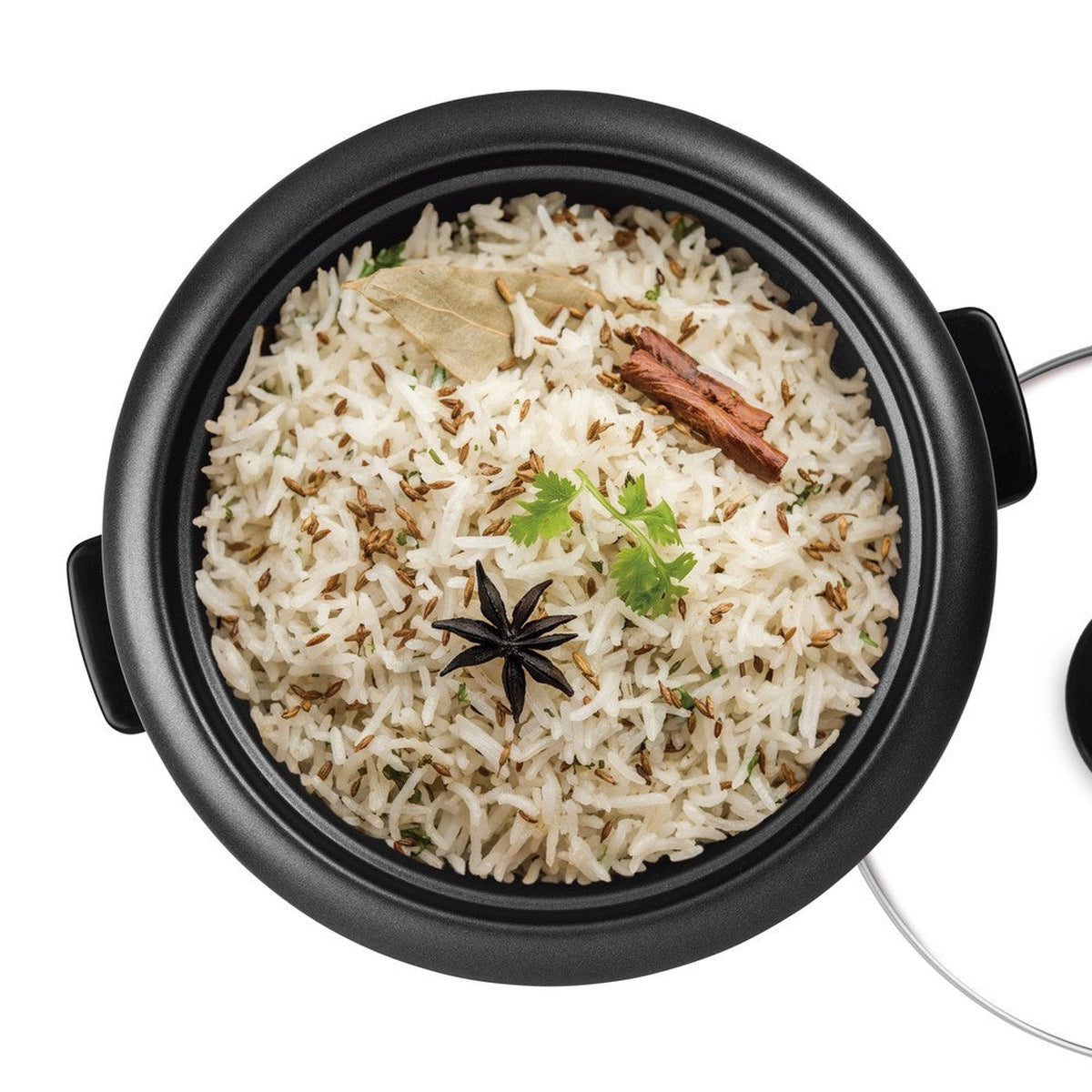 Rijstkoker met gekookte rijst, kruiden en kruiden. Zwarte pot, witte achtergrond.