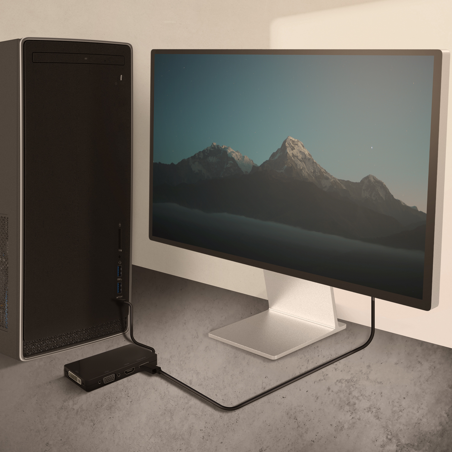 Configuración de ordenador con PC de escritorio, monitor con escena de montaña y adaptador negro.