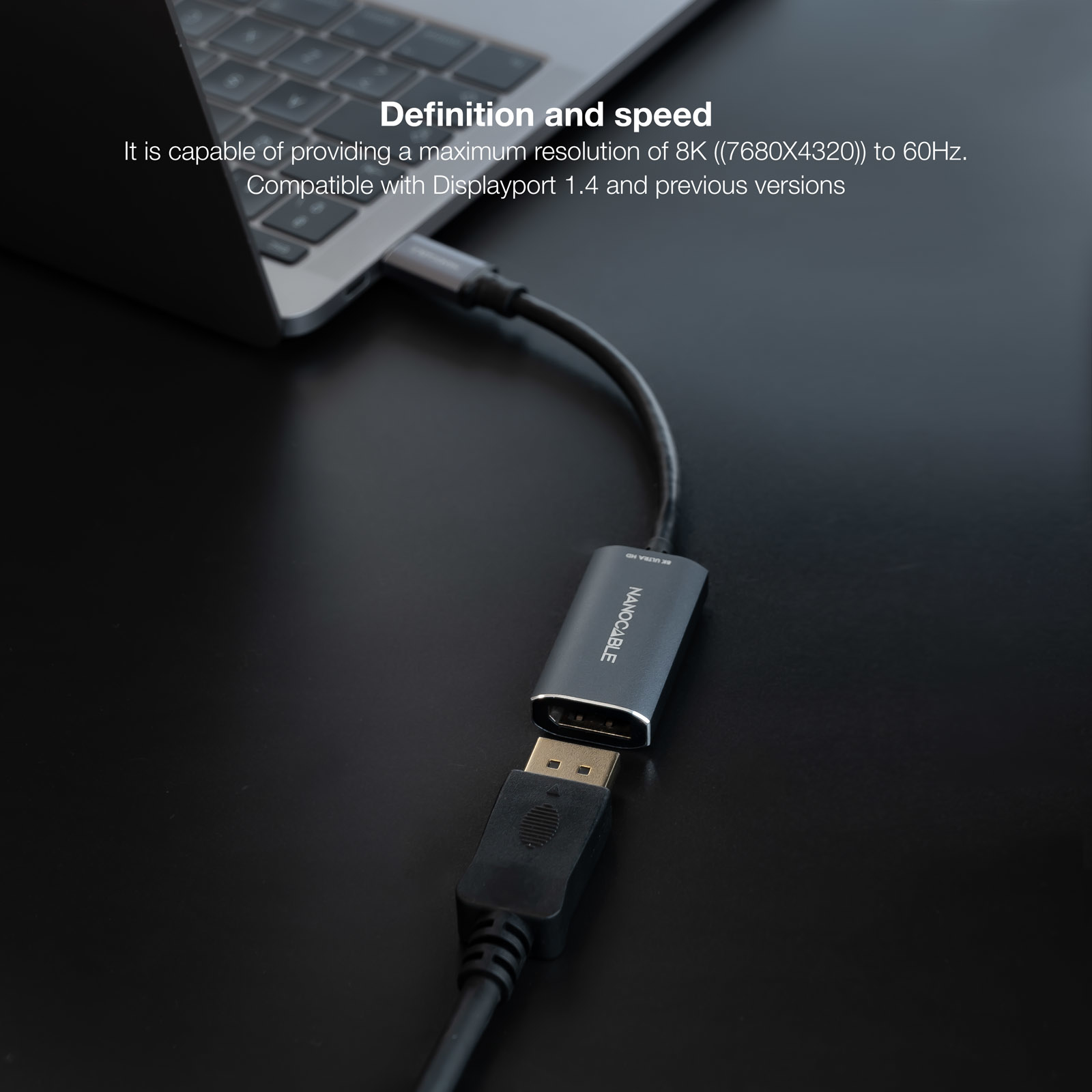 Schwarzer und silberner Adapter, der mit einem Laptop und einem schwarzen Kabel verbunden ist.