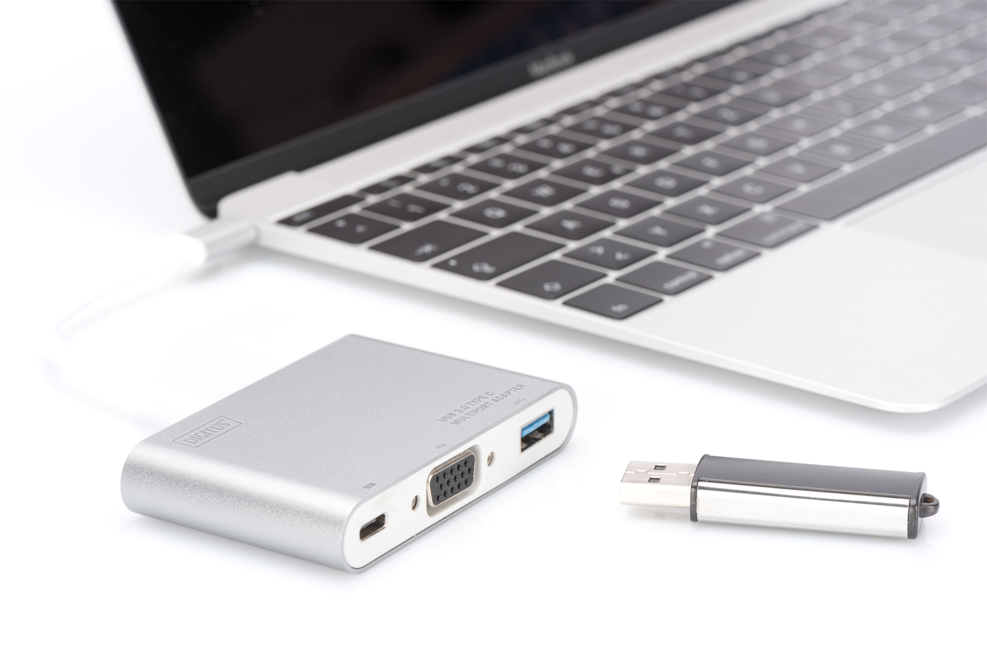 Gümüş adaptör ve USB sürücülü dizüstü bilgisayar. Adaptör dizüstü bilgisayara bağlı, yanında USB sürücüsü.