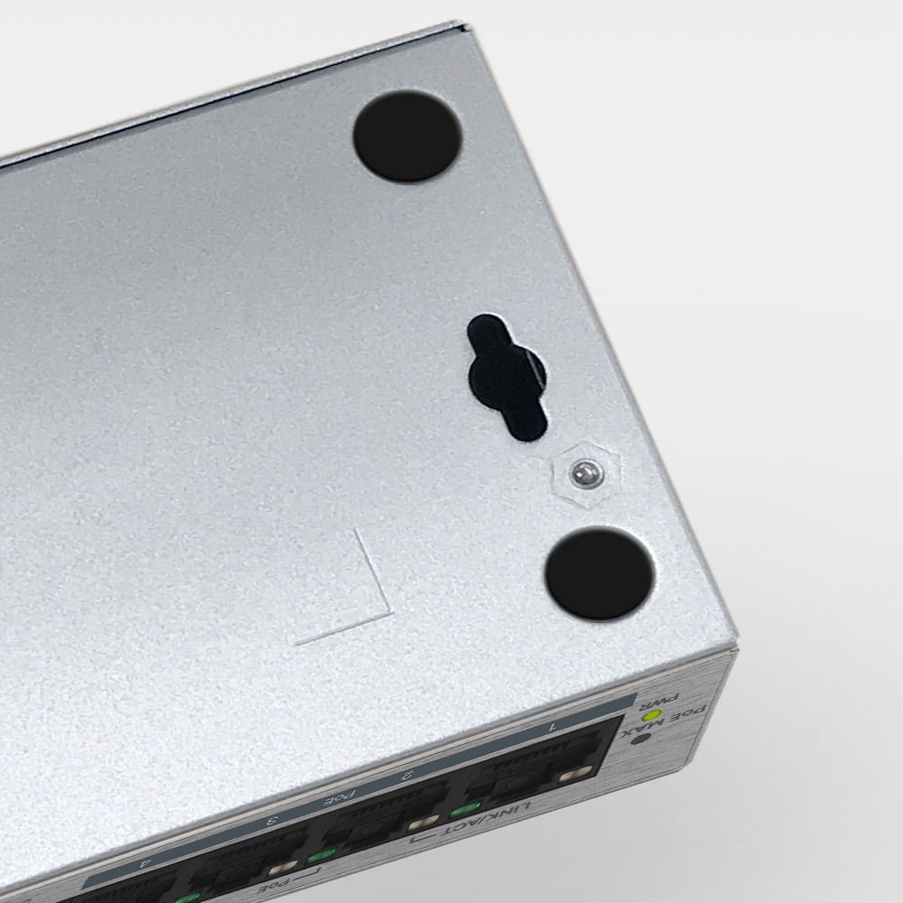 Zbliżenie spodu srebrnego przełącznika z czterema portami i czarną śrubą.