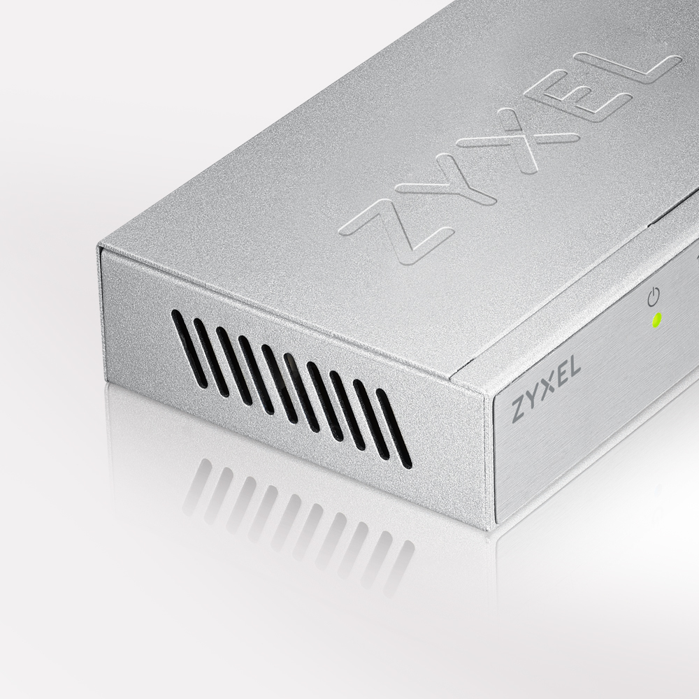 Router Zyxel argentato con fori di ventilazione e una luce verde su una superficie bianca.