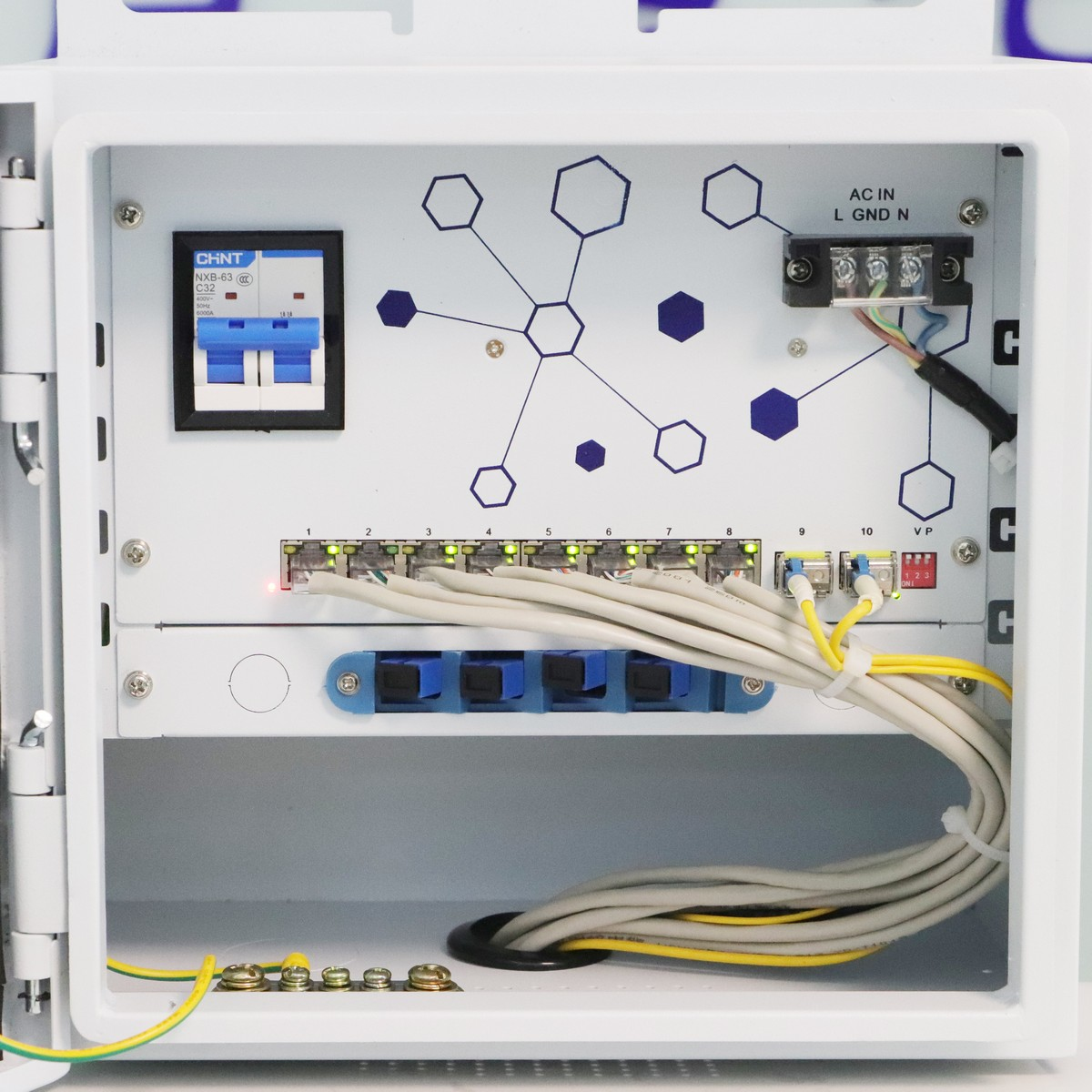 Otwarta biała skrzynka z komponentami sieciowymi, kablami i wyłącznikiem obwodu.