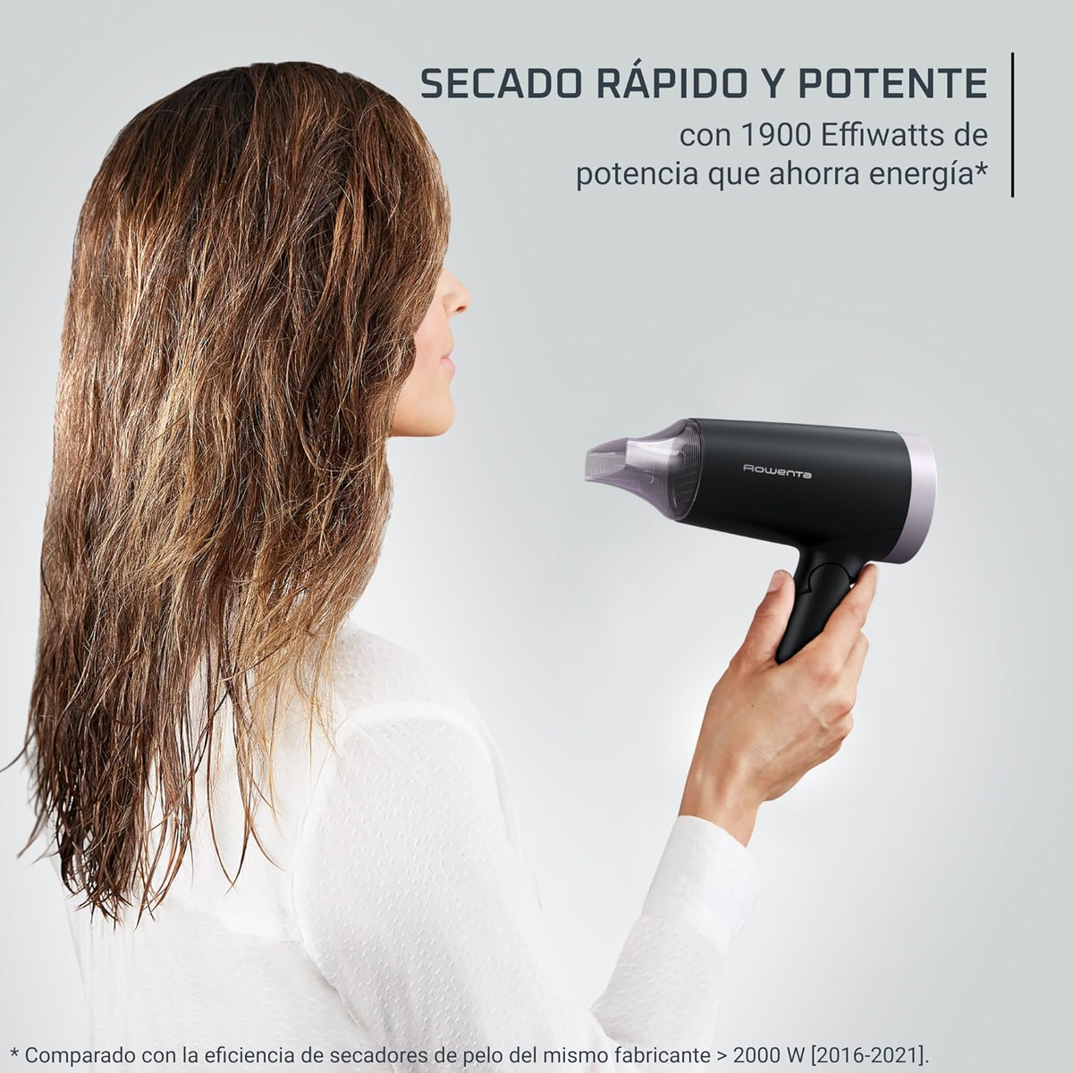 Mujer secando el cabello con secador negro. Texto en español detrás.
