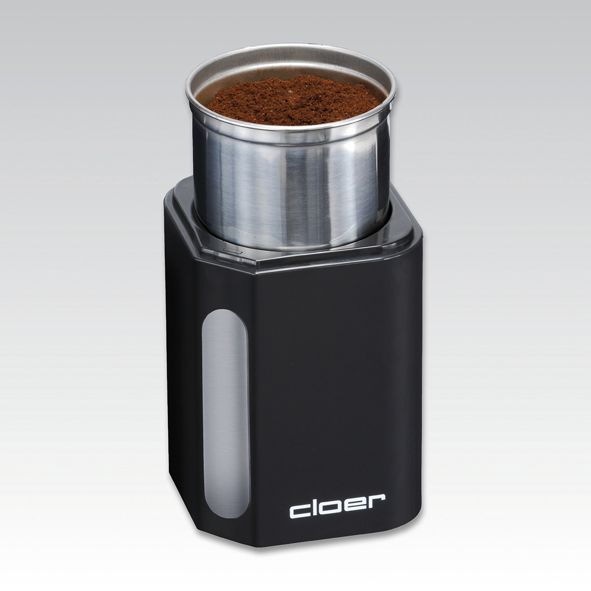Eine schwarze Cloer Kaffeemühle. Sie enthält gemahlenen Kaffee. Die Mühle hat einen chromähnlichen Behälter.