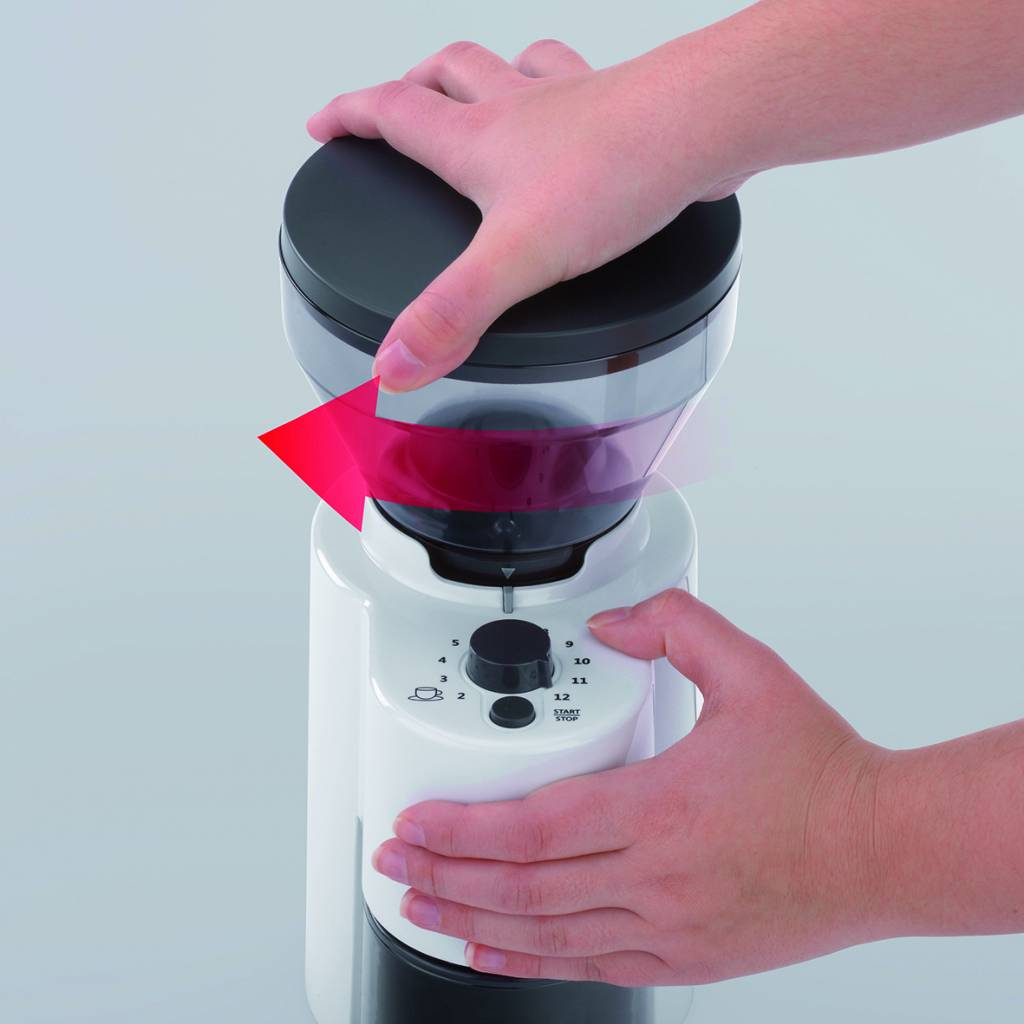 Person dreht eine Kaffeemühle. Weiße und schwarze Farben.