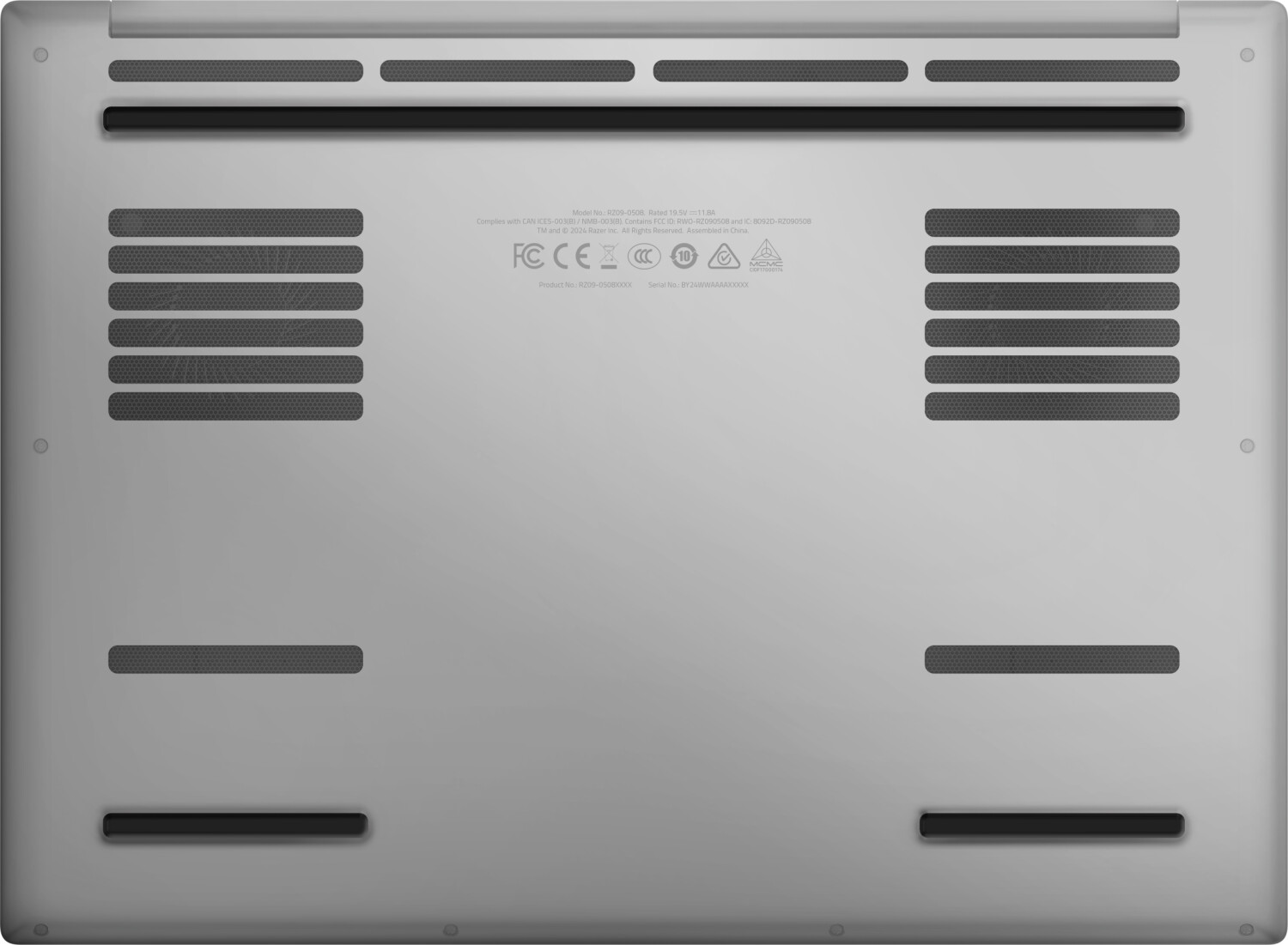 Spód laptopa pokazujący otwory wentylacyjne, śruby i etykiety.