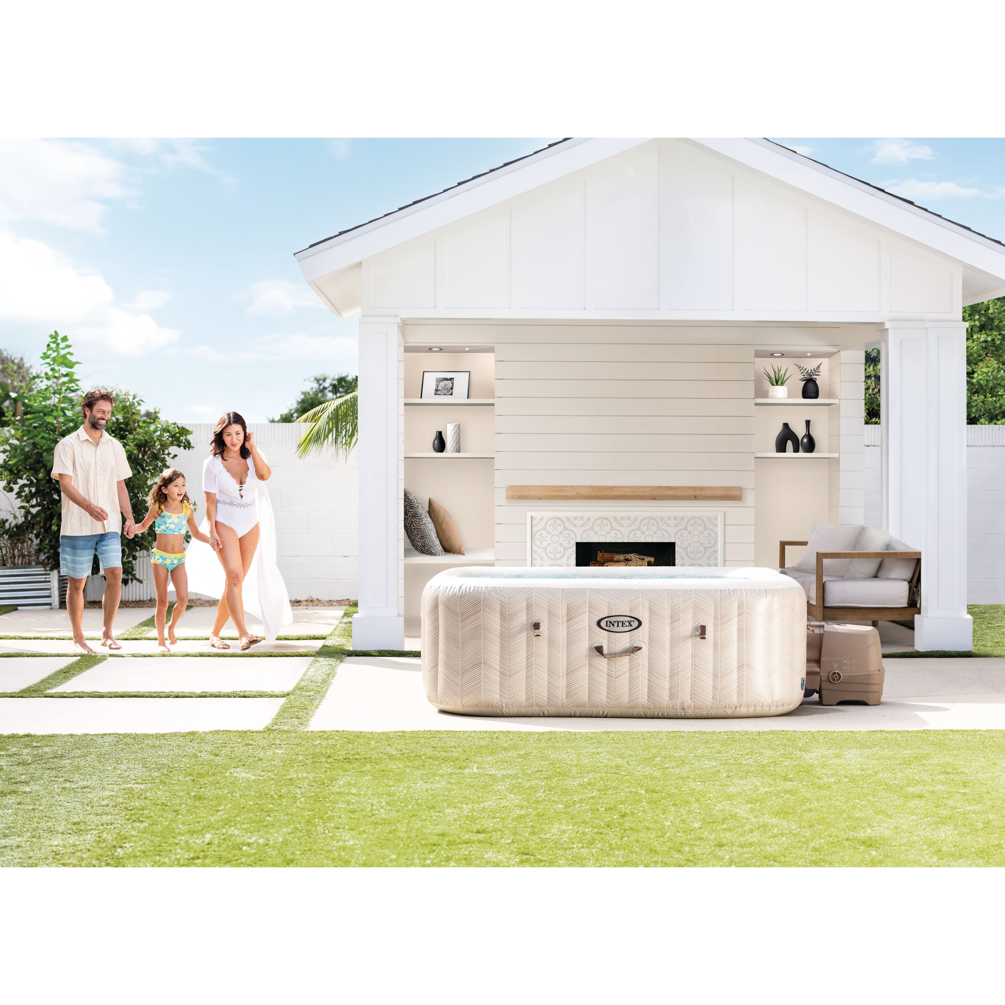 Rodzina spaceruje po patio w pobliżu altany. Wanna z hydromasażem jest na środku. Zielony trawnik.