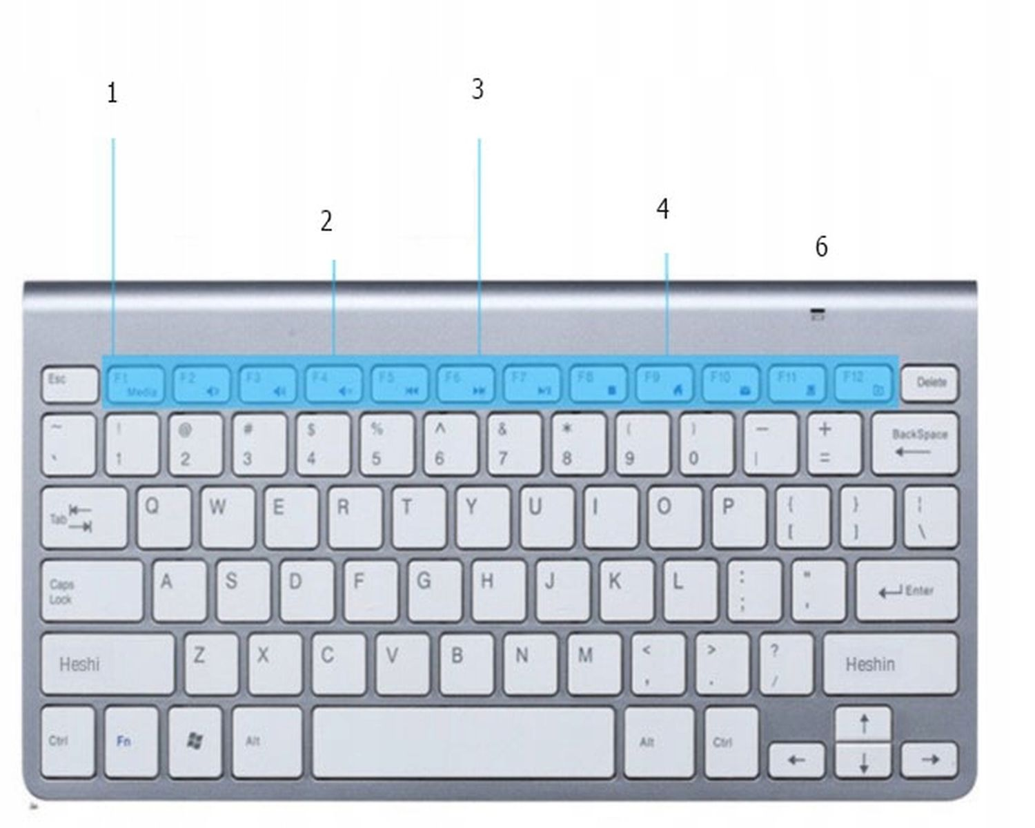 Srebrna klawiatura z cyframi i klawiszami funkcyjnymi. Tło jest białe.