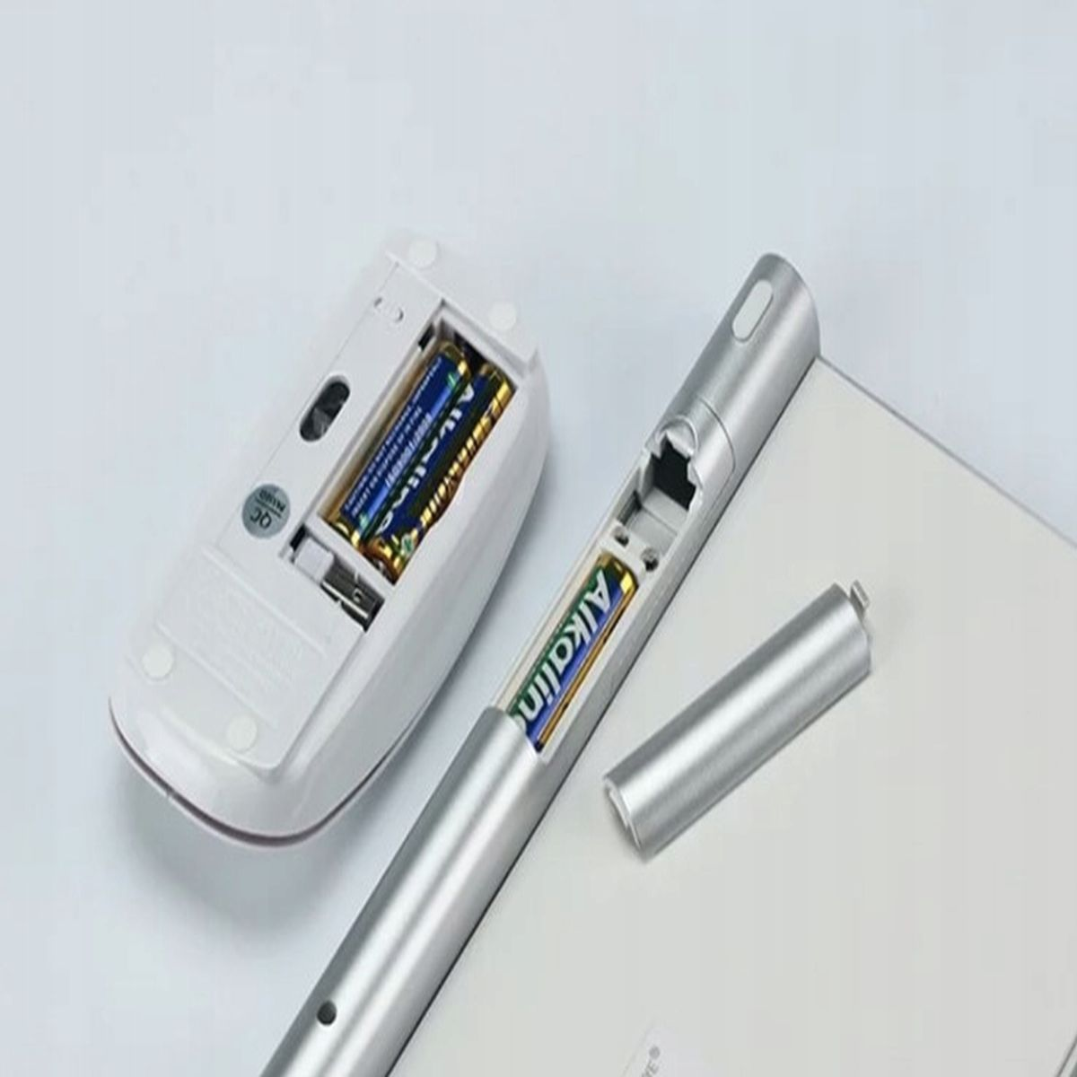 Mysz i długopis z bateriami. Białe tło.