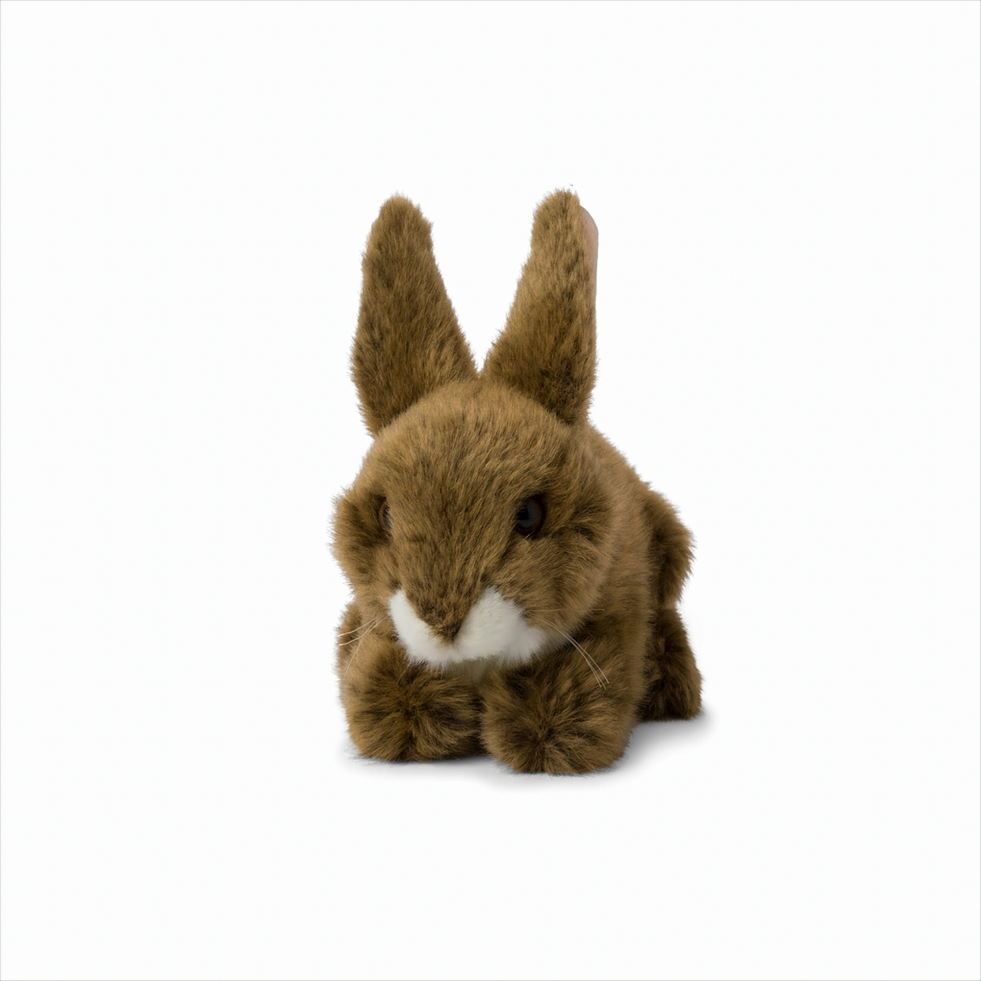 Un lapin en peluche marron. Il a de longues oreilles et regarde devant lui.