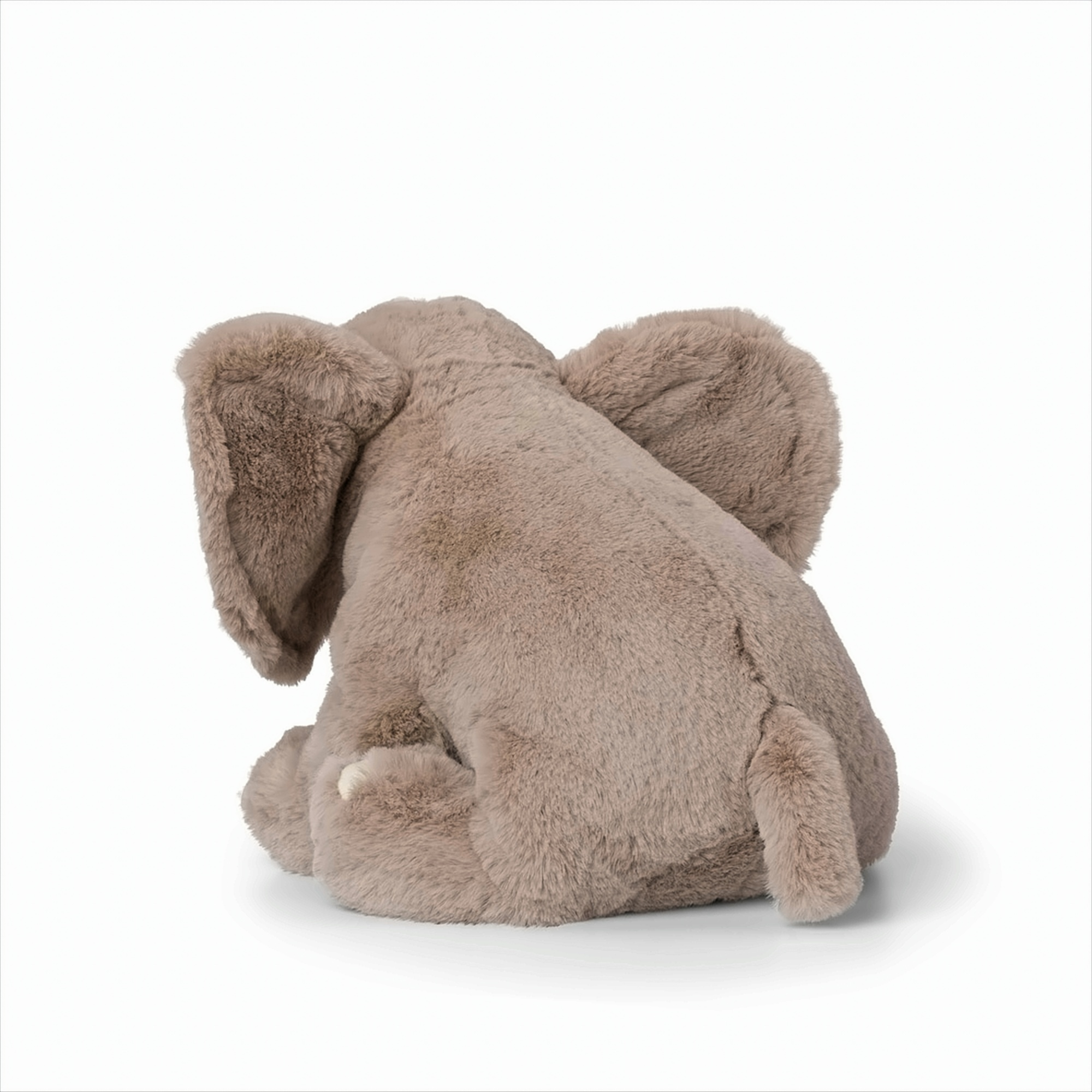 Un jouet éléphant en peluche, vu de dos, sur fond blanc.