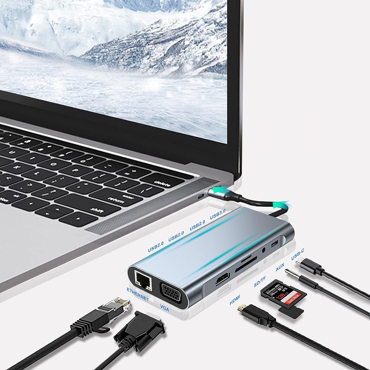 Laptop conectado a un concentrador con múltiples cables, incluyendo Ethernet y HDMI. Colinas nevadas al fondo.