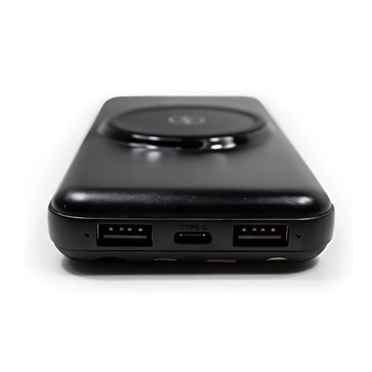 Banco de energía negro. Tiene dos puertos USB, un puerto USB-C y un área de carga redonda.