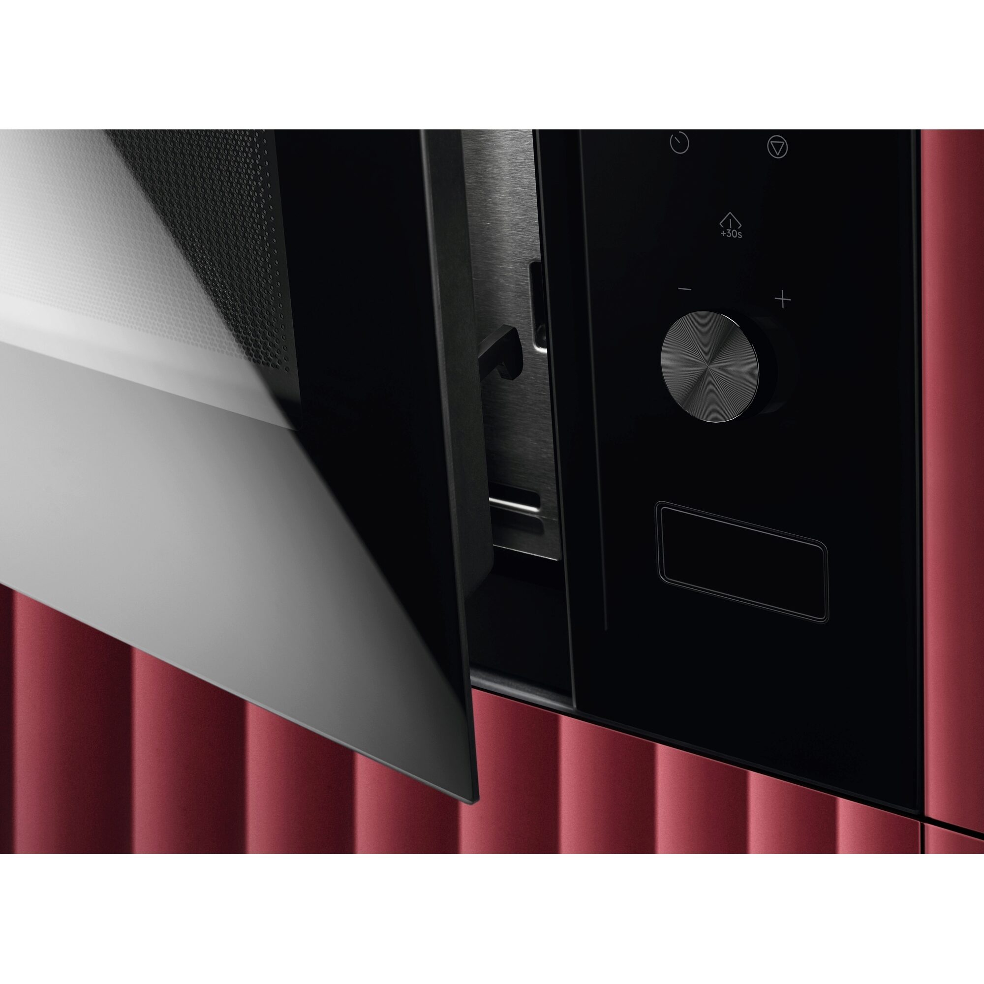 Kuchenka mikrofalowa z uchylonymi drzwiami, czerwonym korpusem i pokrętłem.