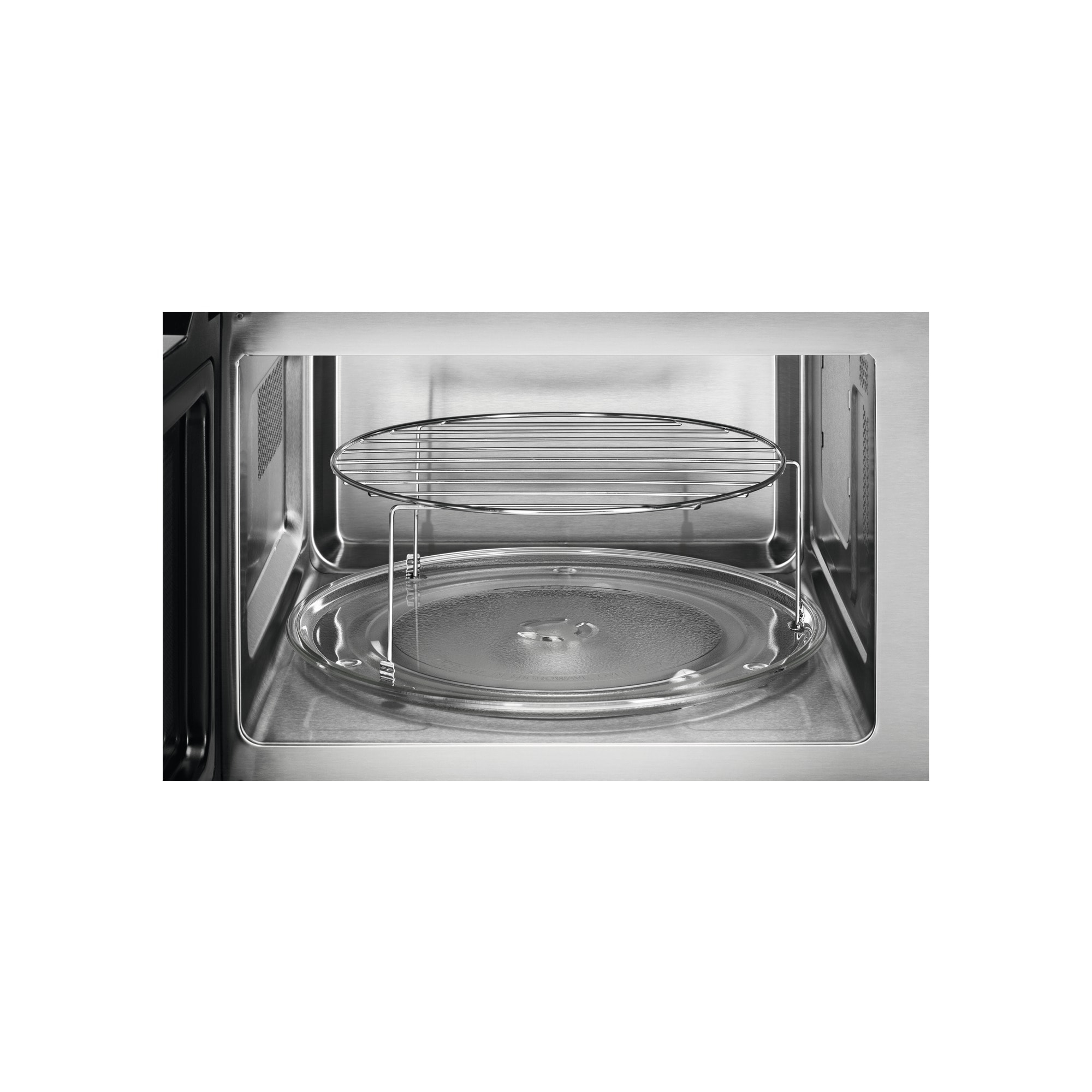 Wnętrze kuchenki mikrofalowej. Widoczny szklany talerz i metalowy ruszt.