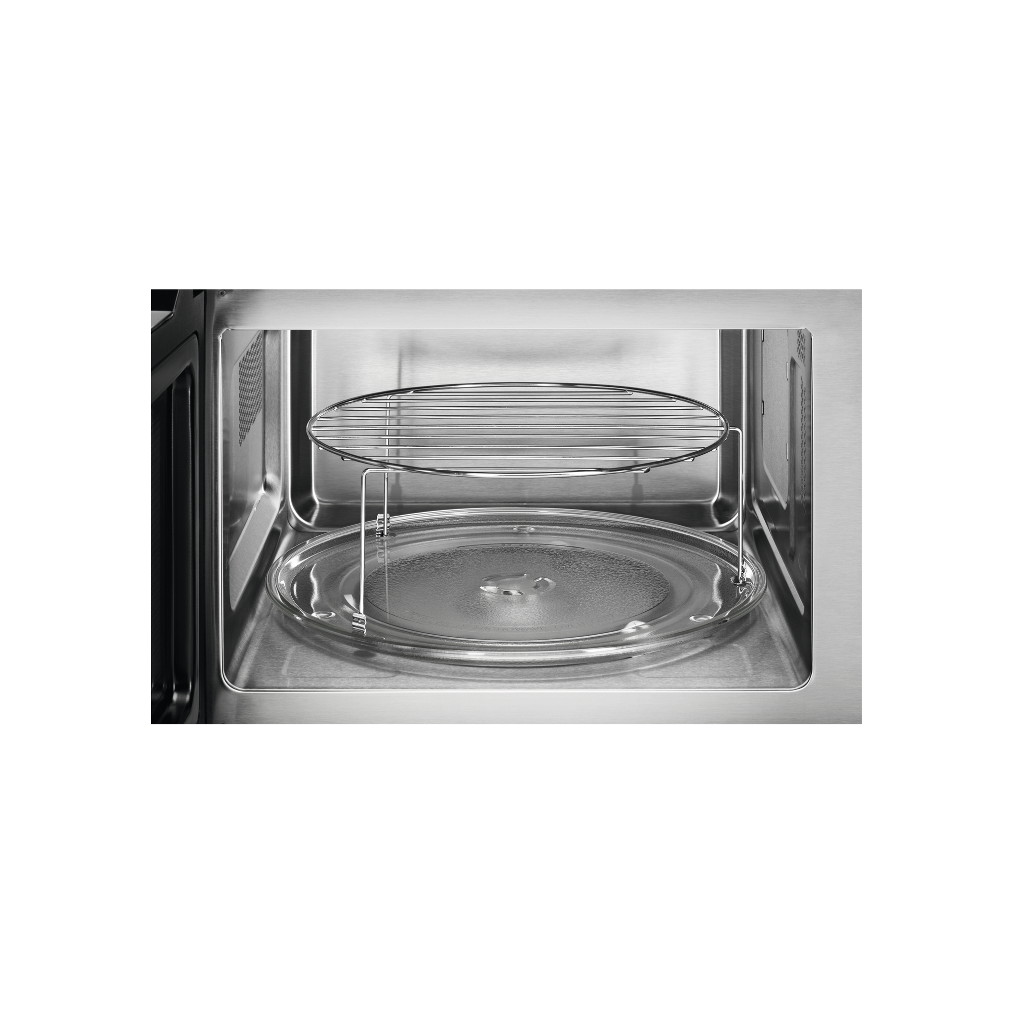 Wnętrze kuchenki mikrofalowej. Widoczny szklany talerz i metalowa kratka.