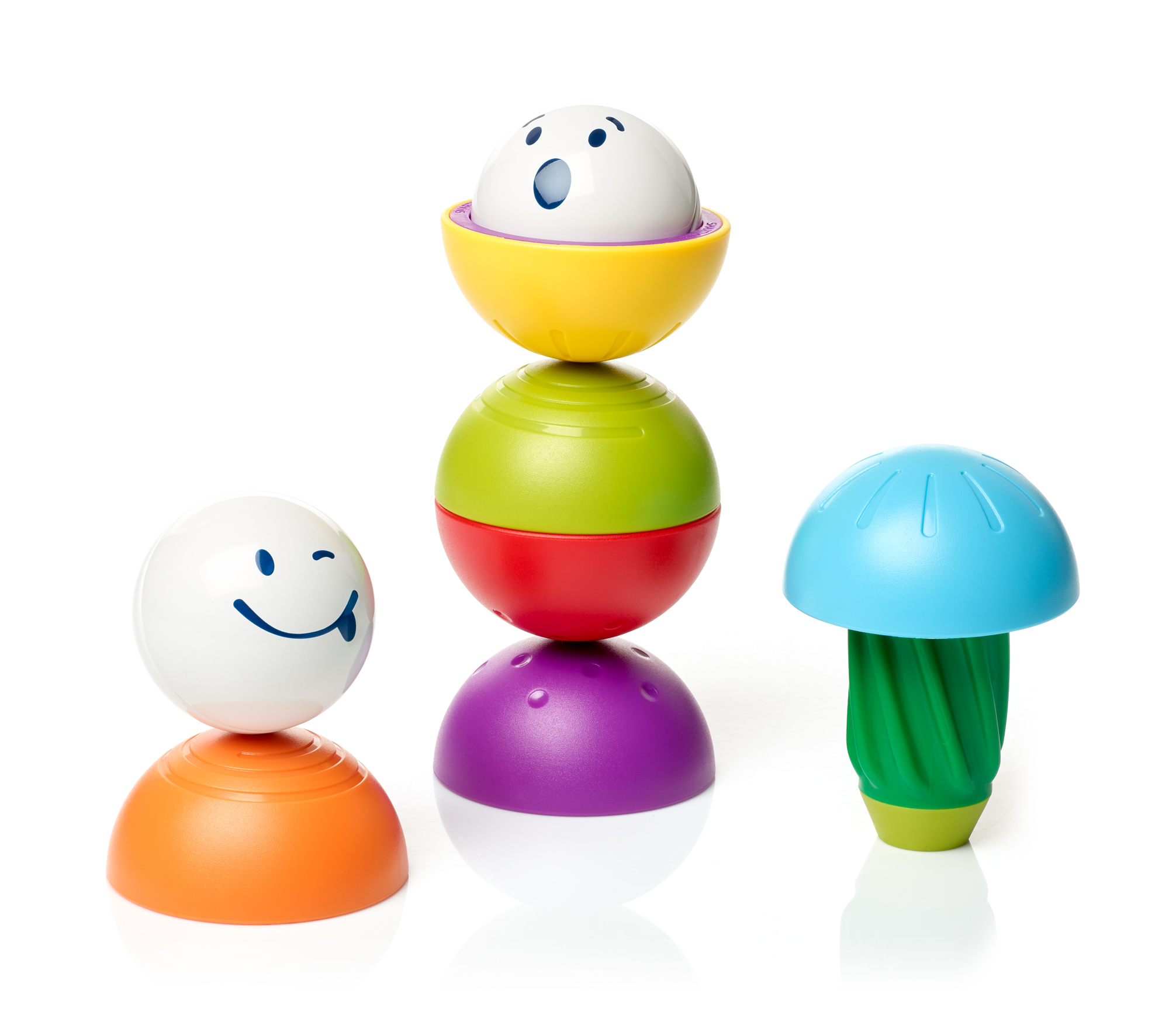 Tre palline colorate impilate l'una sull'altra, con un giocattolo a forma di fungo accanto.