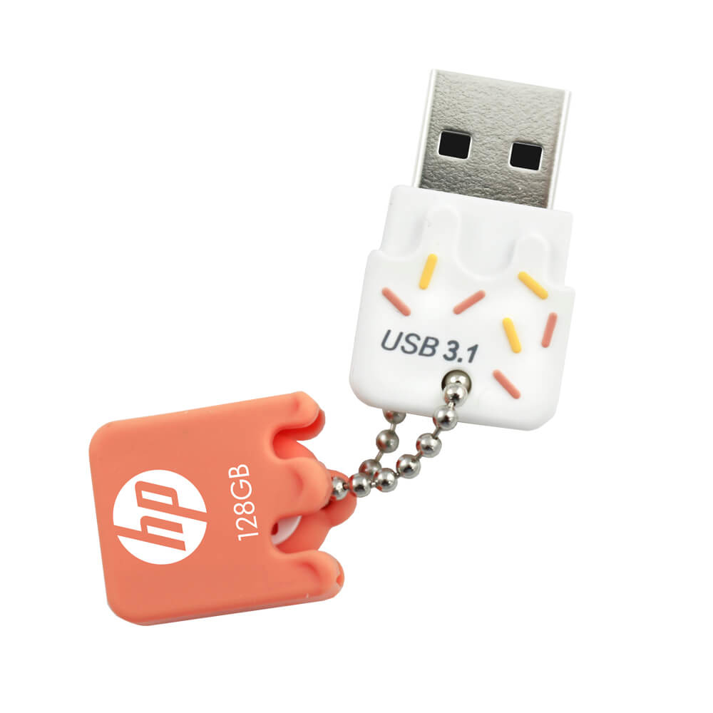 Una memoria USB con forma de pastel, con chispas. Tiene una cadena y una etiqueta color melocotón.