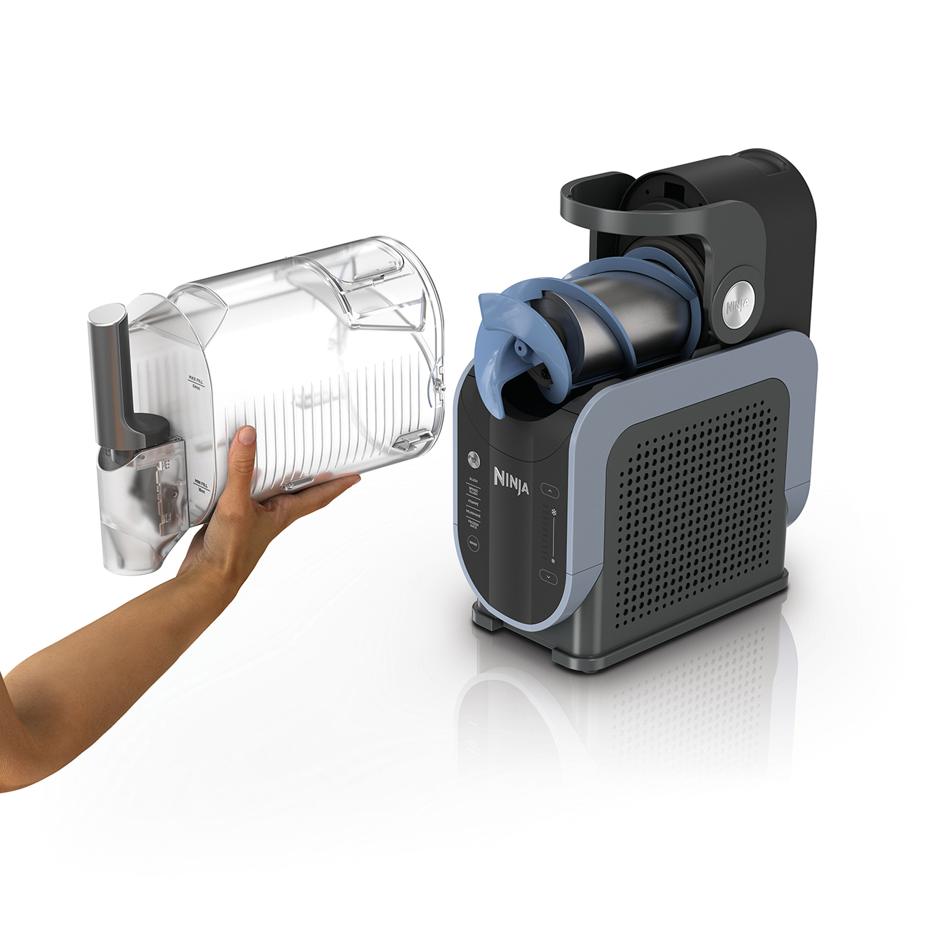 Ręka trzyma przezroczysty pojemnik obok wyciskarki Ninja z niebieskim świdrem.