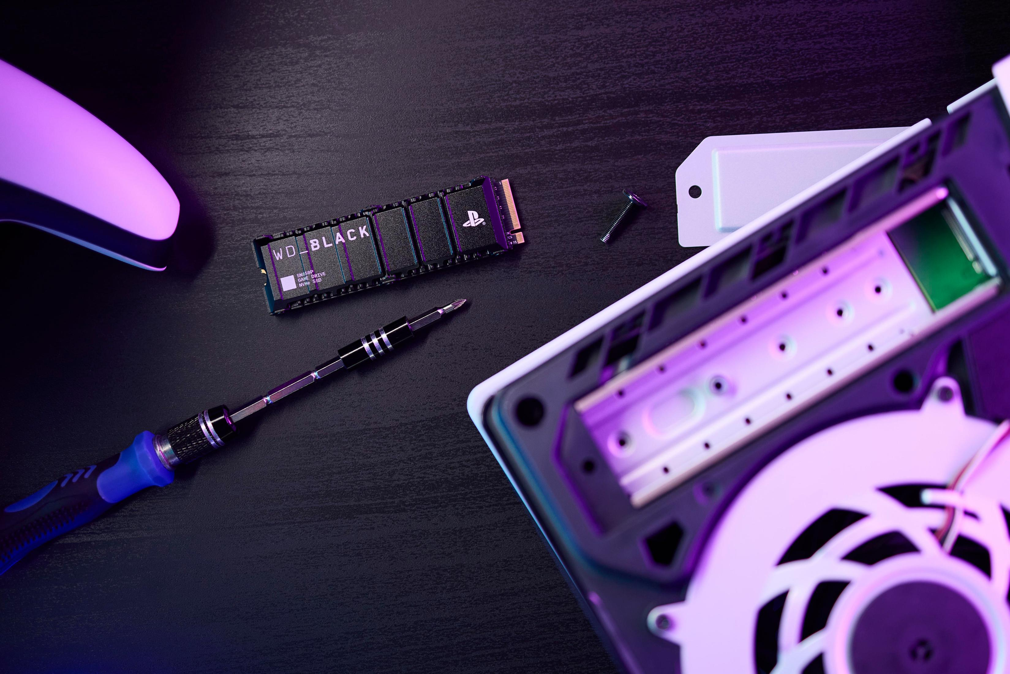 PS5 z dyskiem SSD WD Black, śrubokrętem i komponentami na ciemnej powierzchni.